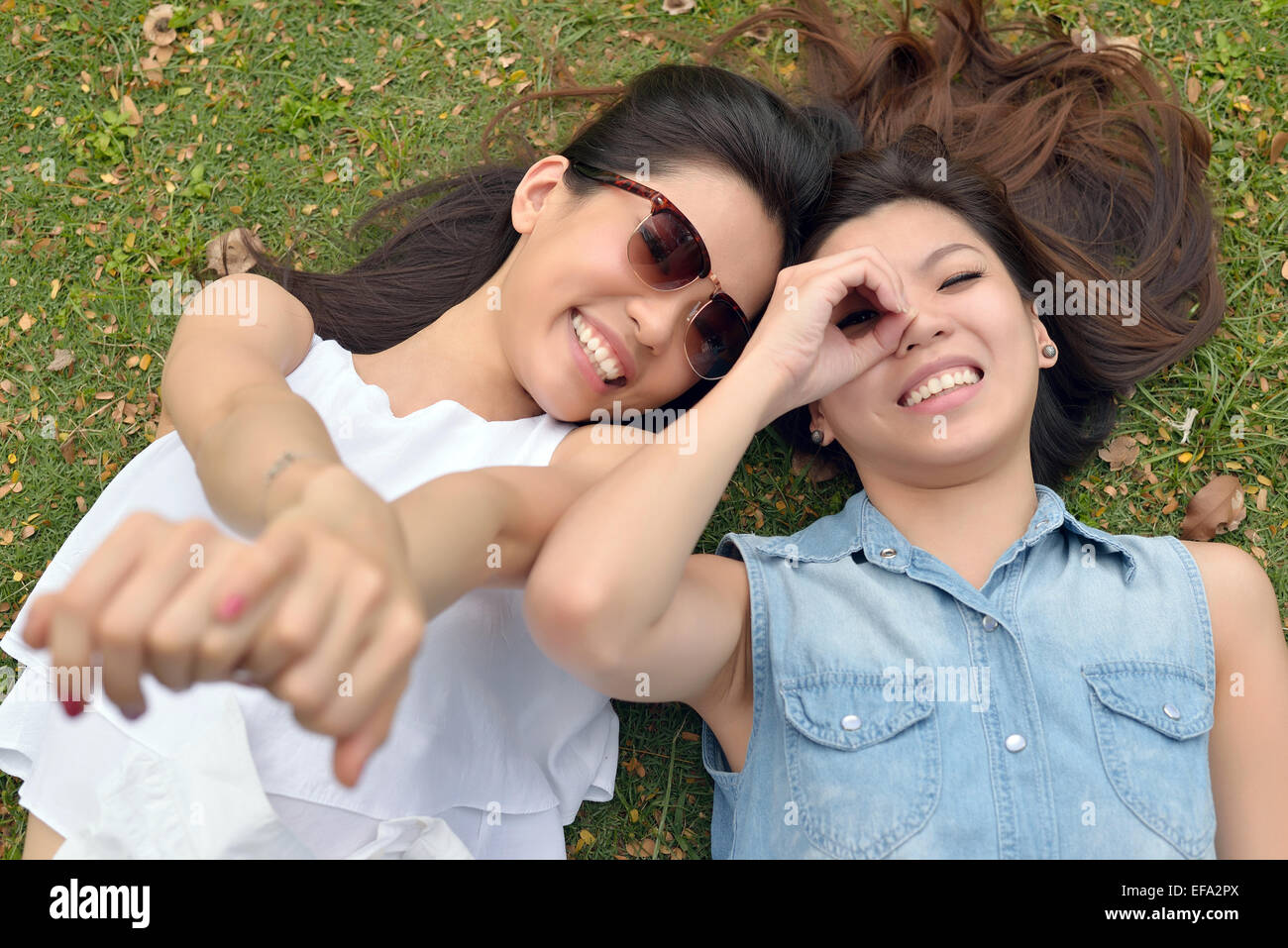Ritratto di due belle , giovani donne , sdraiarsi sul prato Foto Stock