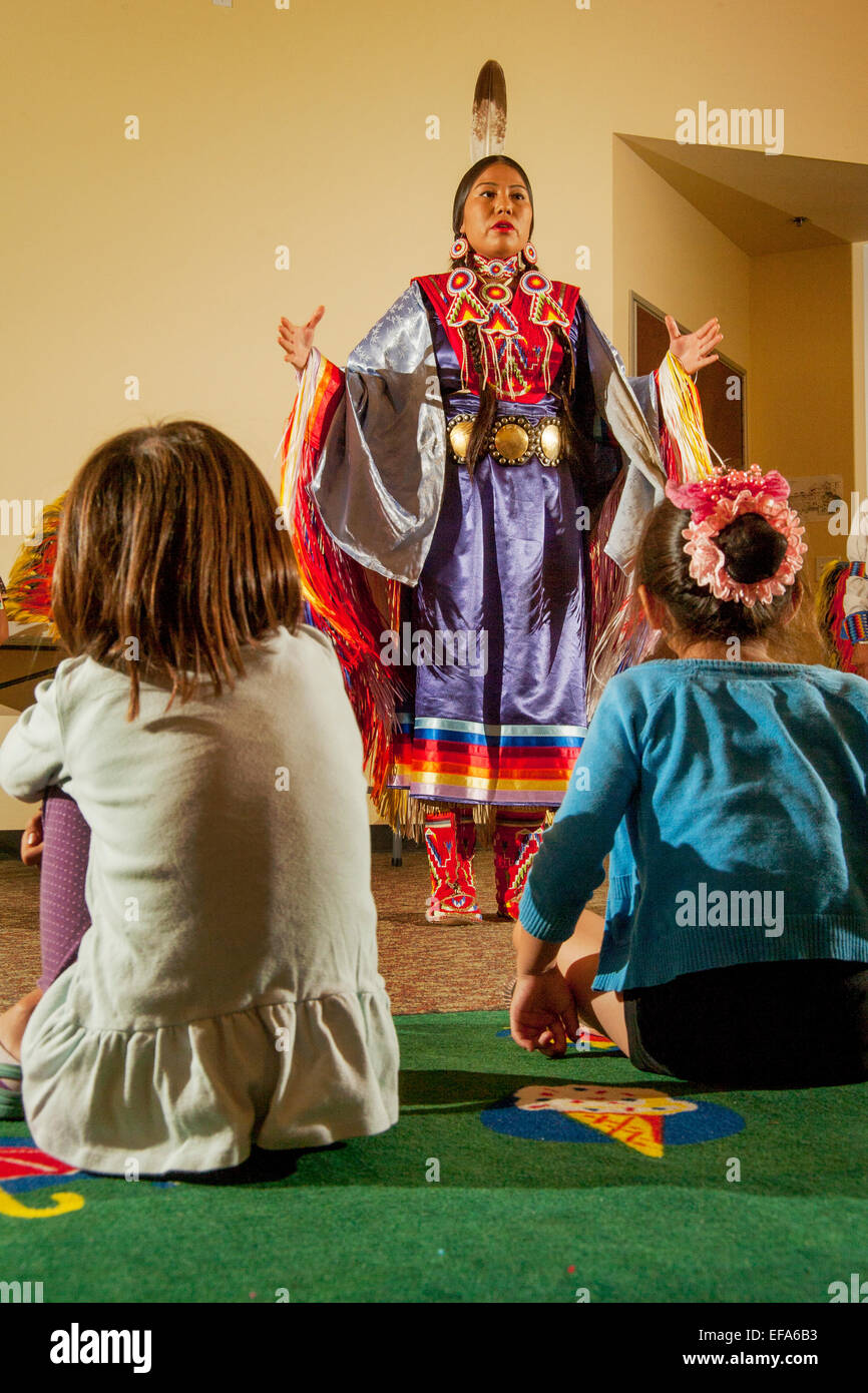 Prima di un pubblico giovane, un Indiano Navajo spiega la femmina-solo scialle  fantasia danza indossando costumi tribali durante una performance dei  Nativi Americani balli in Laguna Niguel, CA, biblioteca pubblica Foto stock  -
