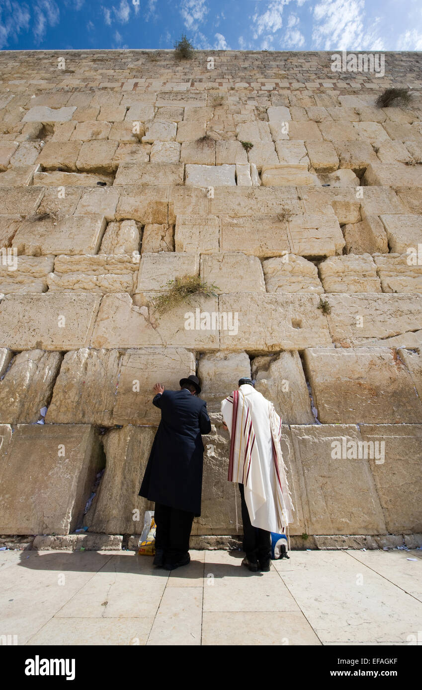 Due uomini ebrei sono in preghiera davanti al muro occidentale nella città vecchia di Gerusalemme Foto Stock
