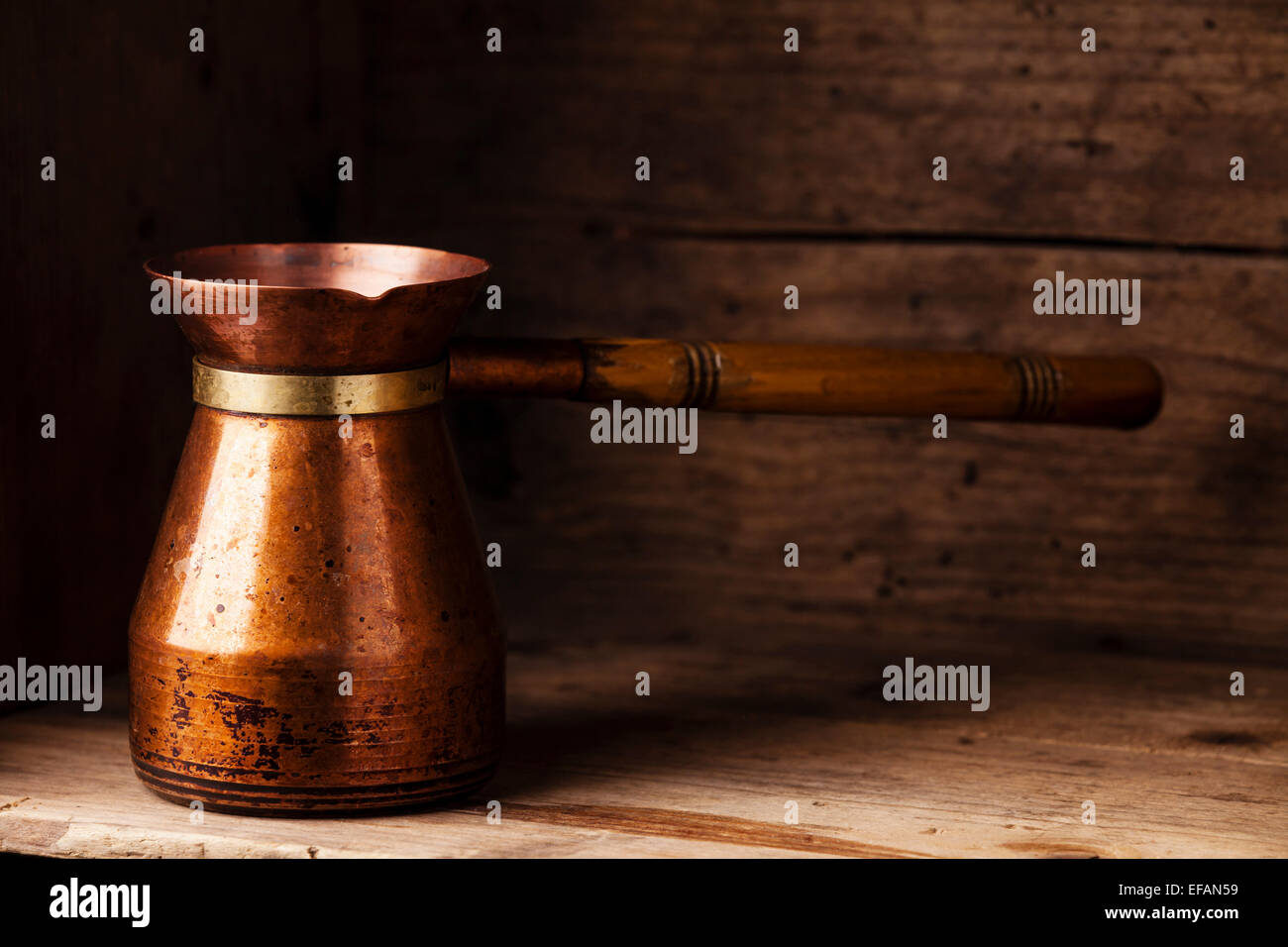Nero caffè in turco Cezve su sfondo di legno Foto Stock