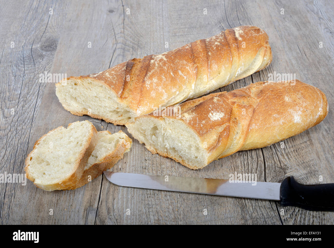 Tagliare il pane francese affettato su un tavolo di legno Foto Stock