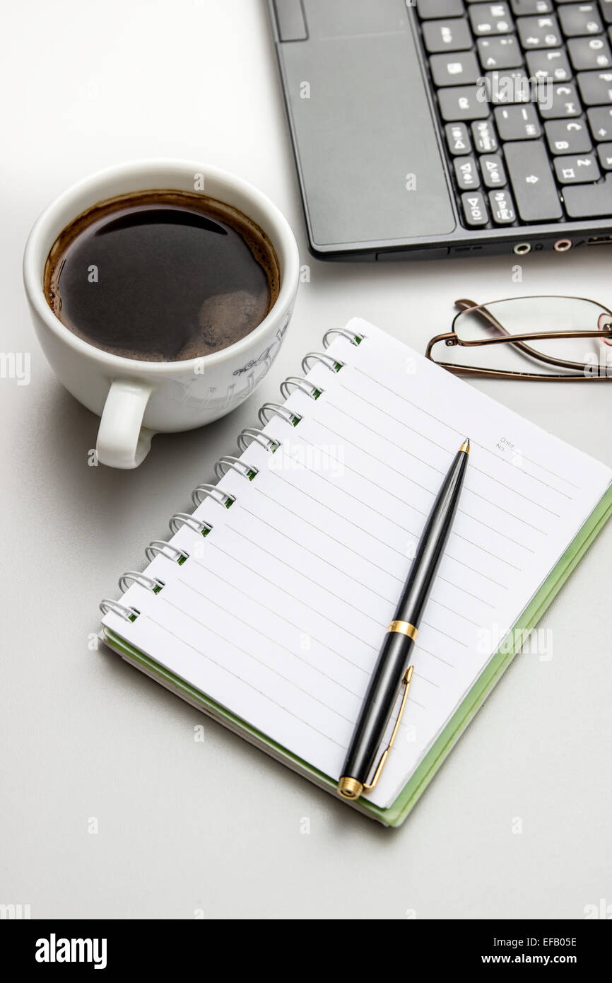 Office desktop con caffè, notepad e bicchieri. Da sopra Foto Stock