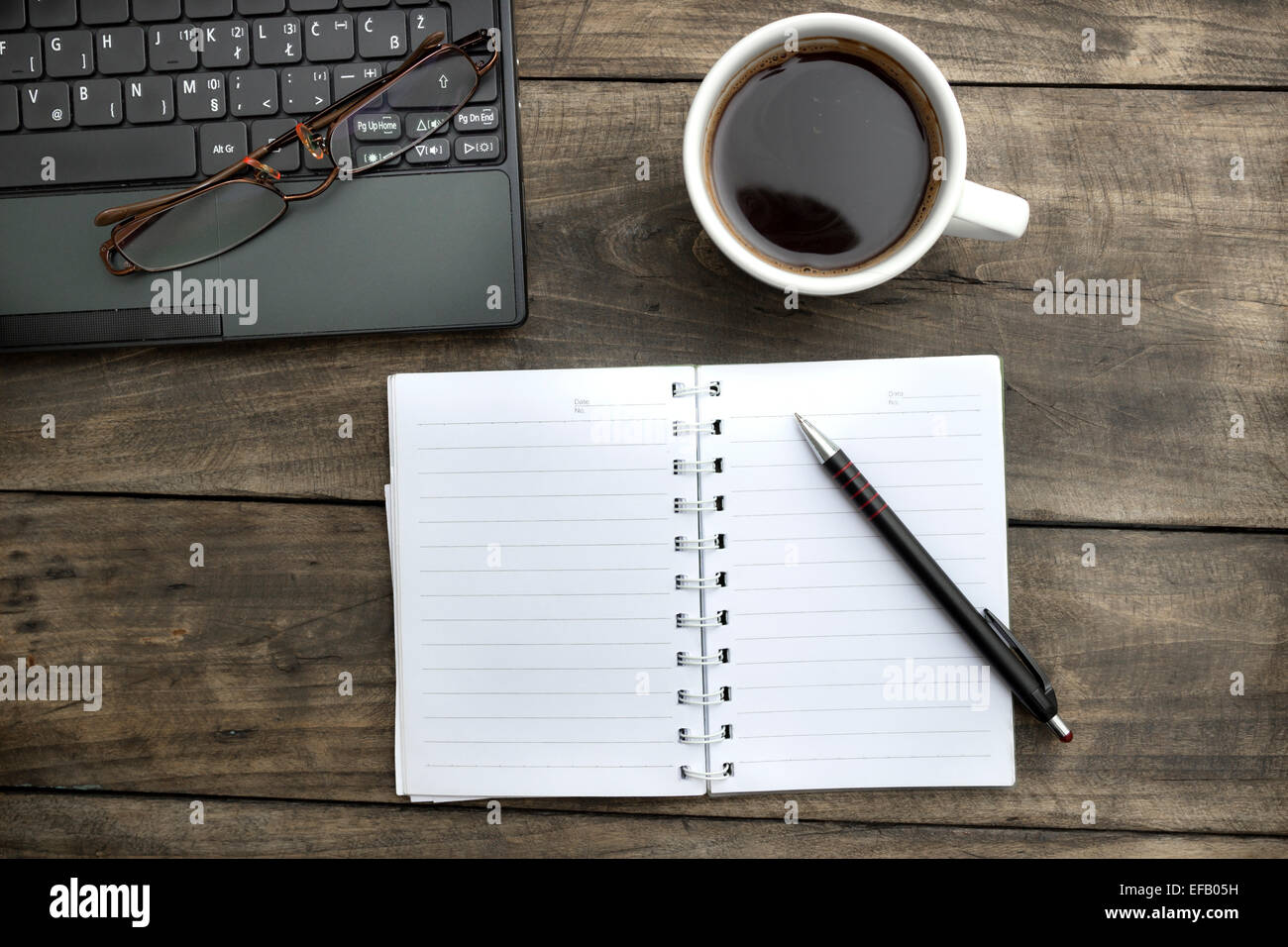 Office desktop con caffè, notepad e bicchieri. Da sopra Foto Stock