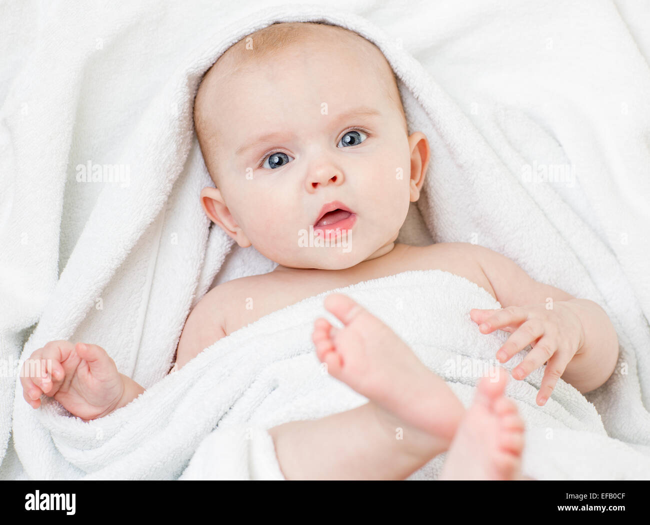 Carino bambina giacente su asciugamano bianco Foto Stock