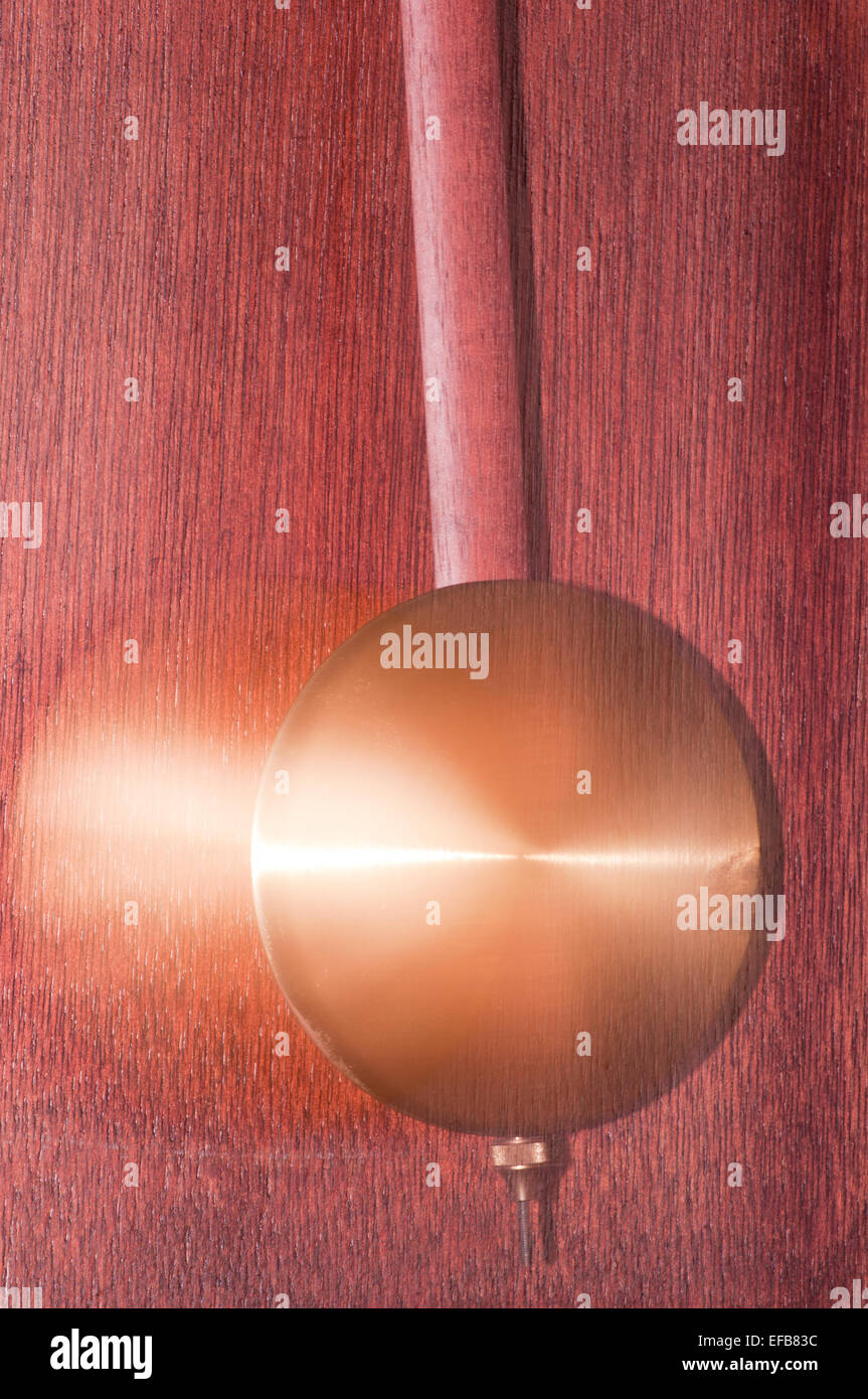 Ottone pendolo Clock con Motion Blur dalla lunga esposizione Plus congelato dal flash della fotocamera Foto Stock