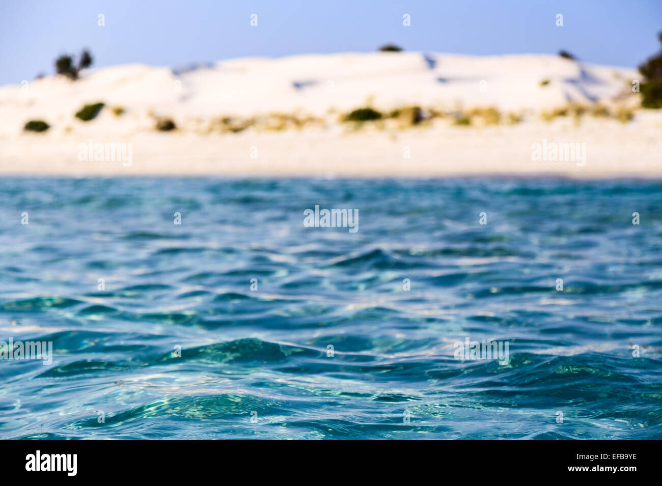 Mare blu acqua sullo sfondo della costa con le dune di sabbia Foto Stock