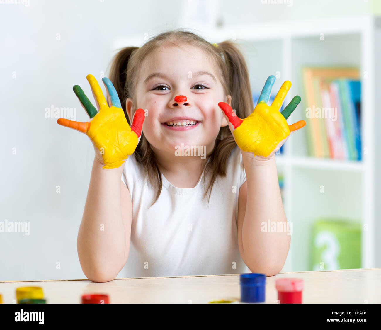 Ritratto di bambino ragazza con il viso e le mani dipinte Foto Stock