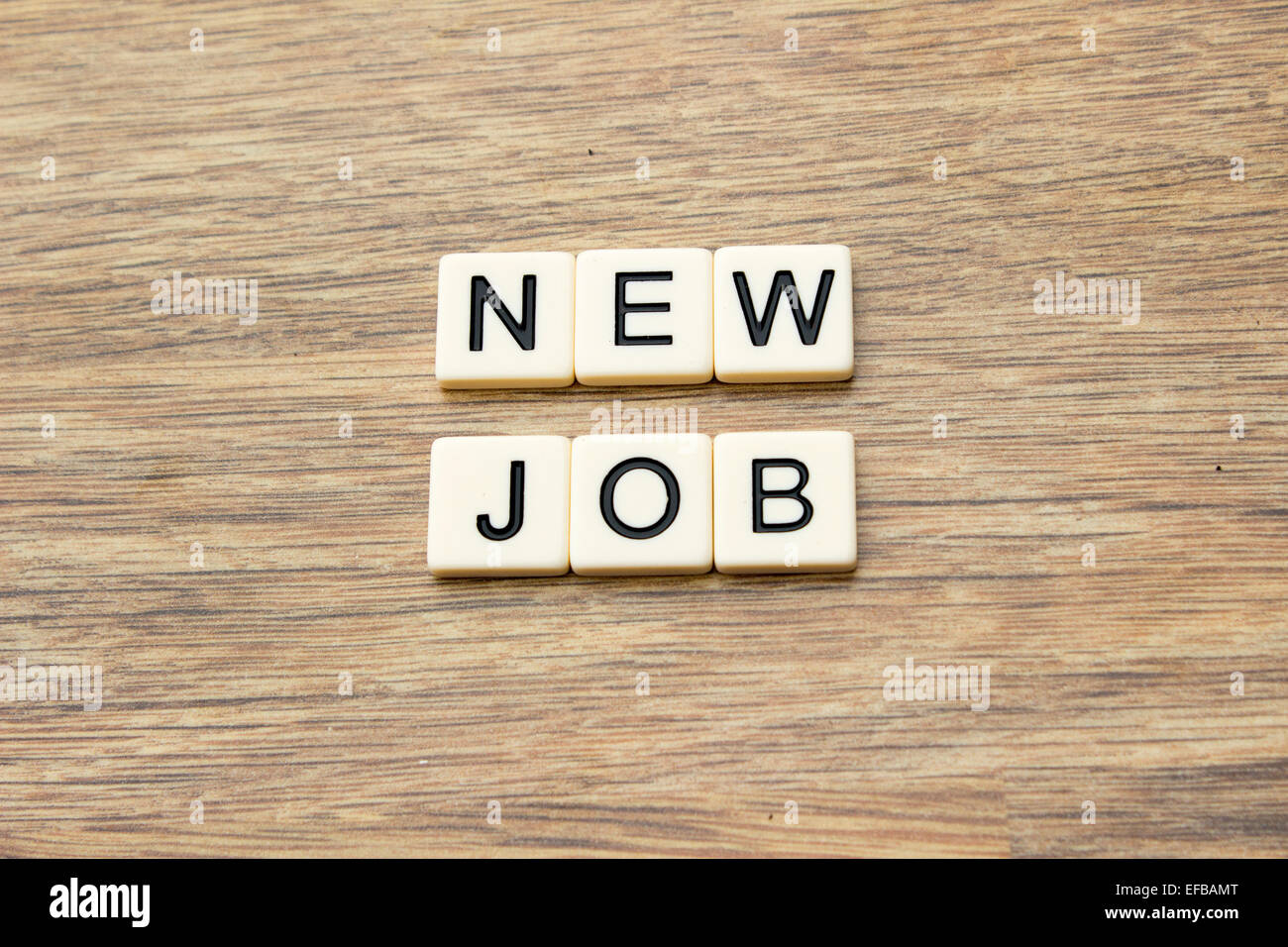 La parola nuovo lavoro scritto in piastrelle su una superficie in legno Foto Stock