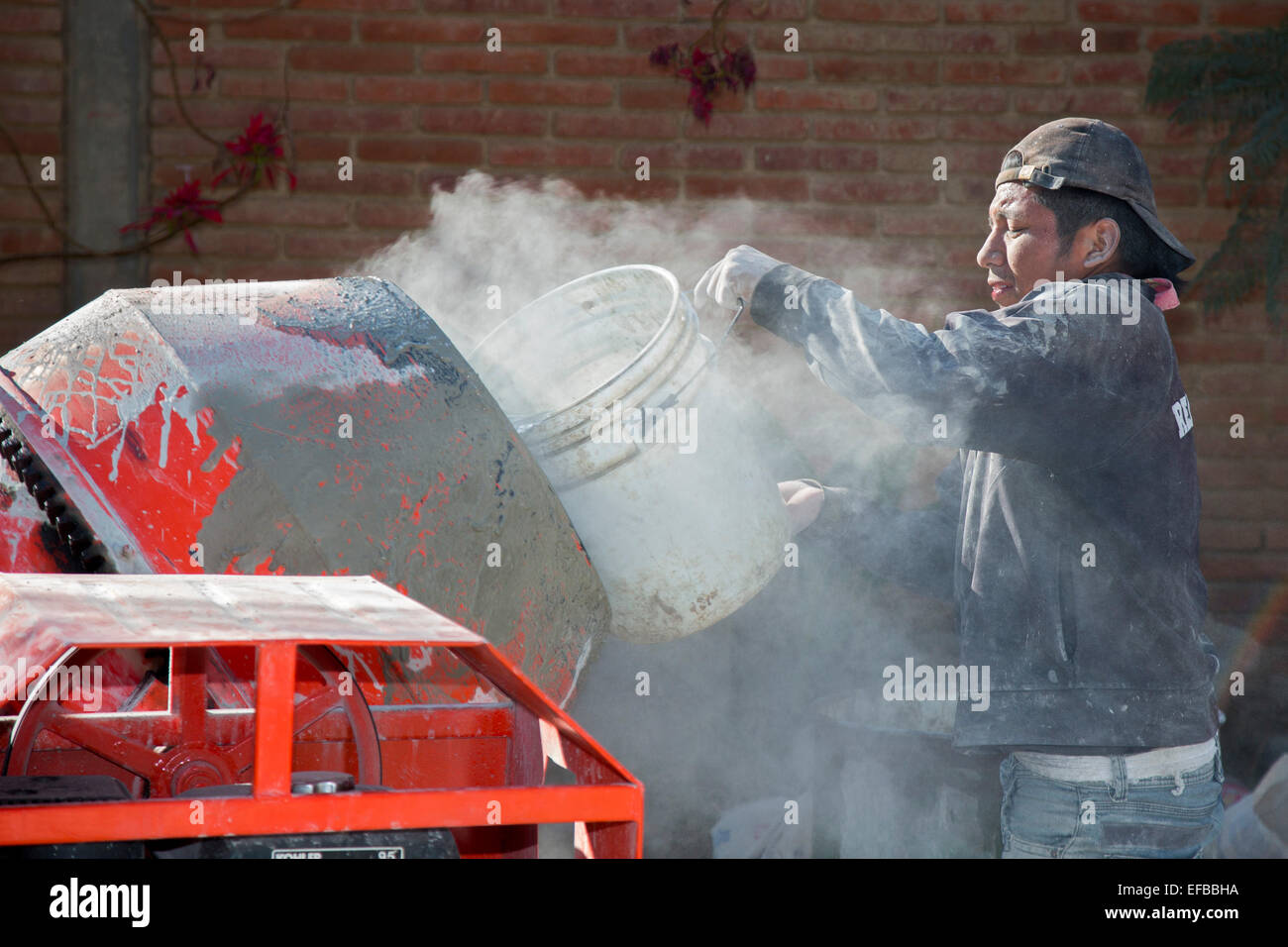 San Sebastian Abasolo, Oaxaca, Messico - Lavoratori cemento di miscela per preparare un ex via lo sporco in un piccolo borgo rurale del Messico. Foto Stock