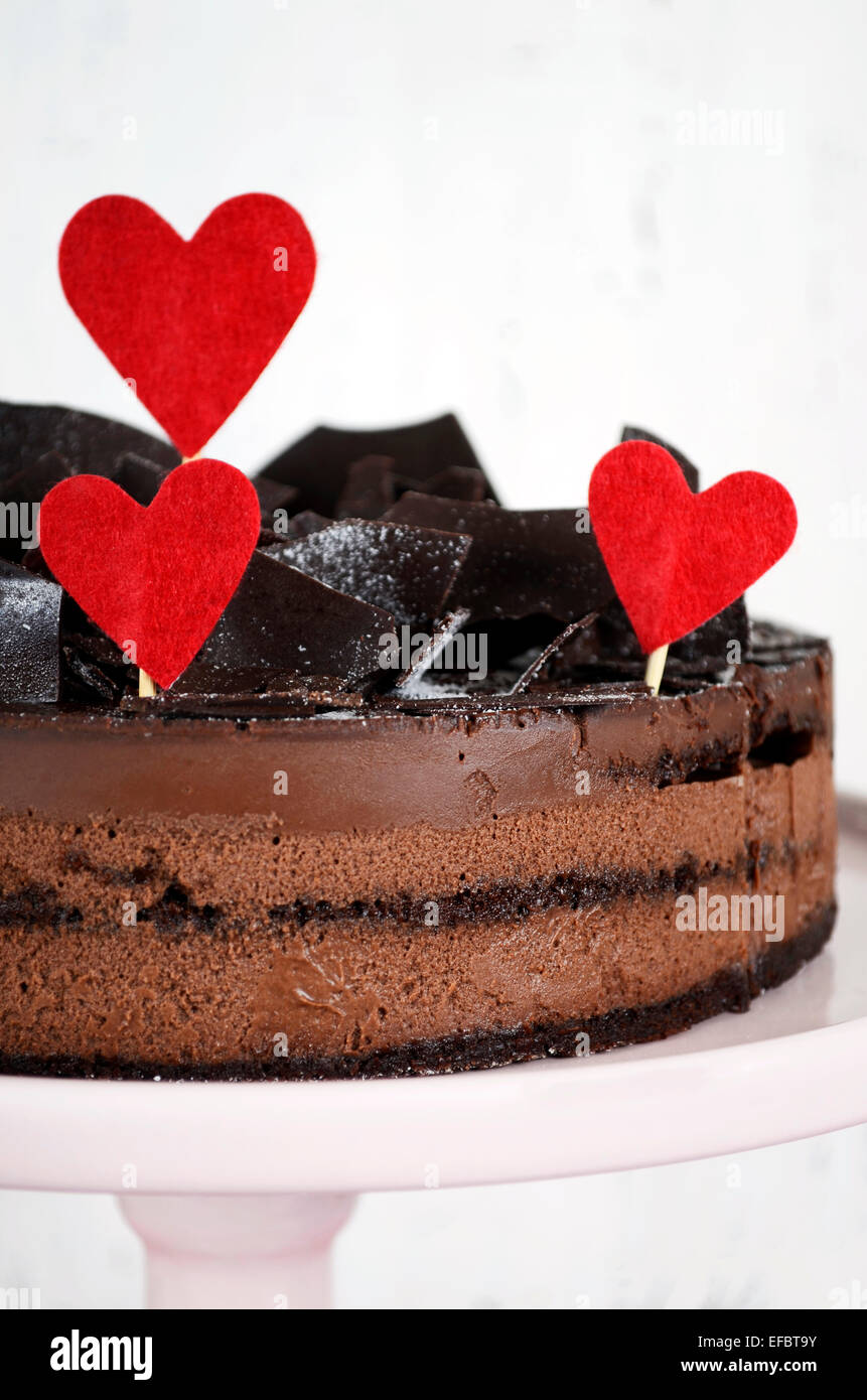 Valentino di mousse al cioccolato gateau di strato torta di cioccolato frammenti di decorazione e di cuori rossi Foto Stock