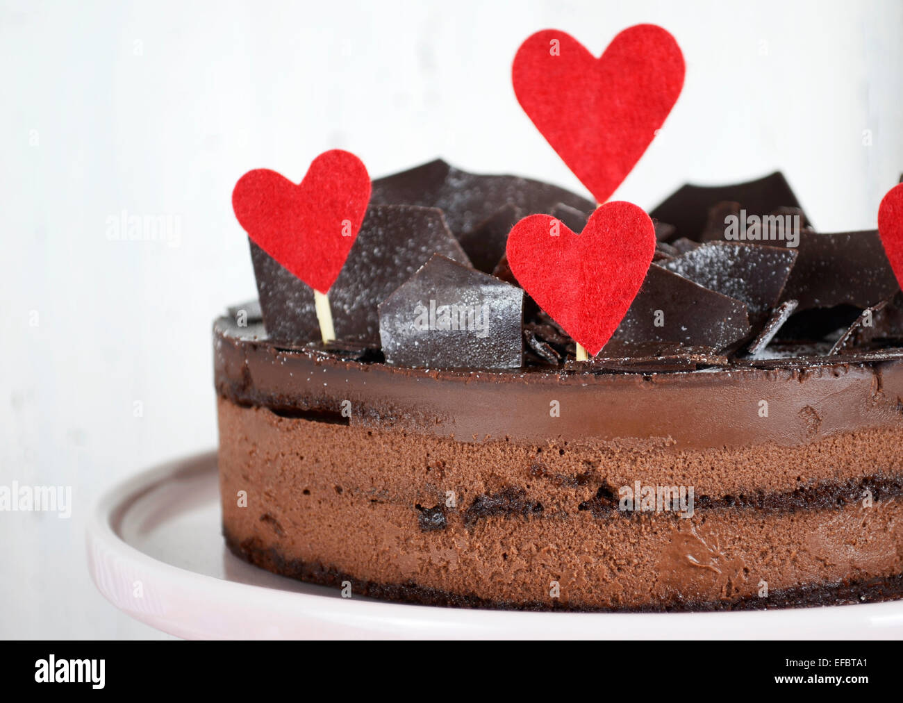 Valentino di mousse al cioccolato gateau di strato torta di cioccolato frammenti di decorazione e di cuori rossi Foto Stock