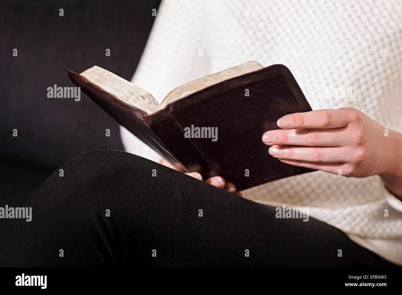 La donna si siede e leggere la Bibbia Foto Stock
