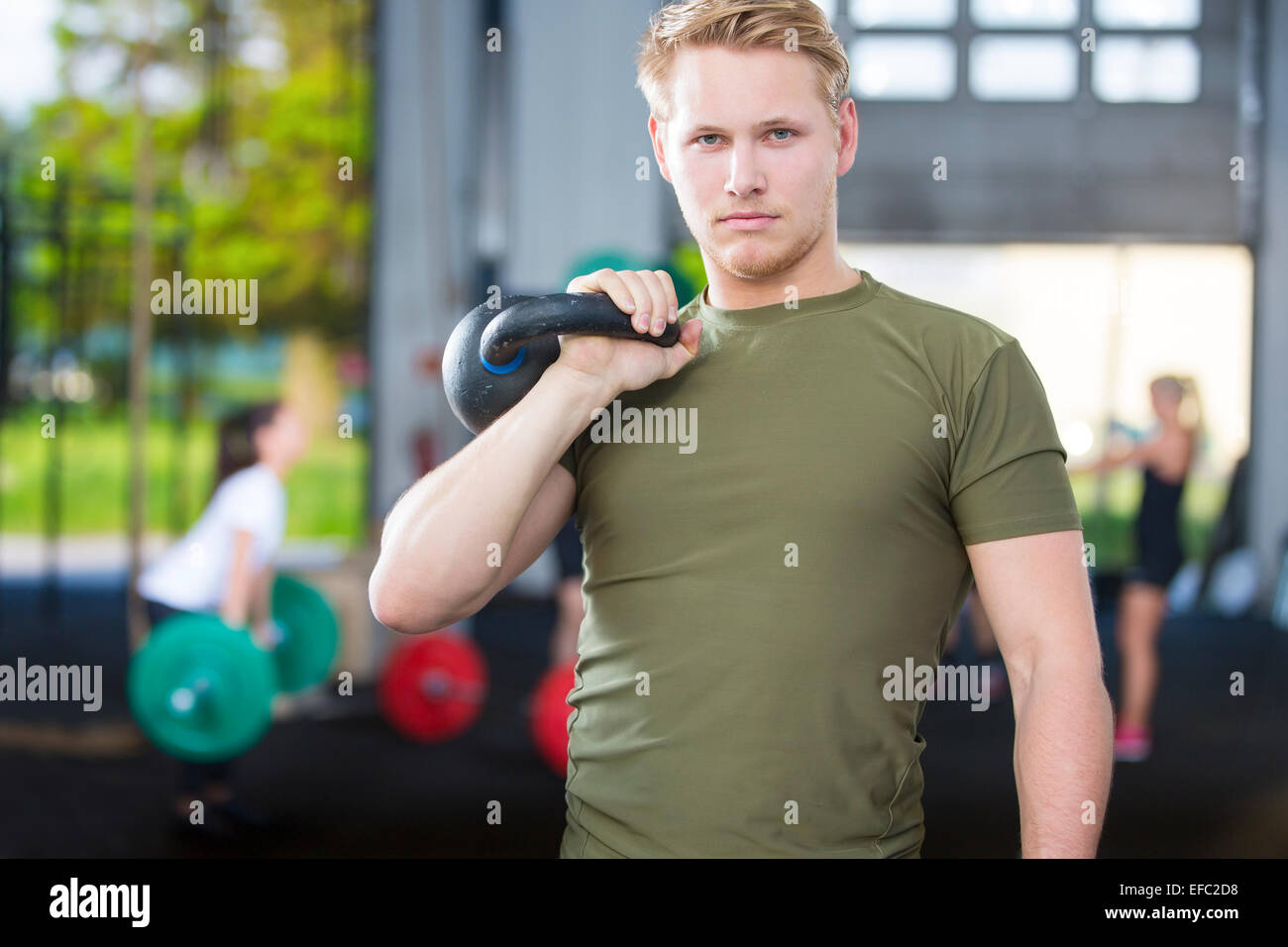 Fiducioso uomo con kettlebell in palestra per il fitness Foto Stock