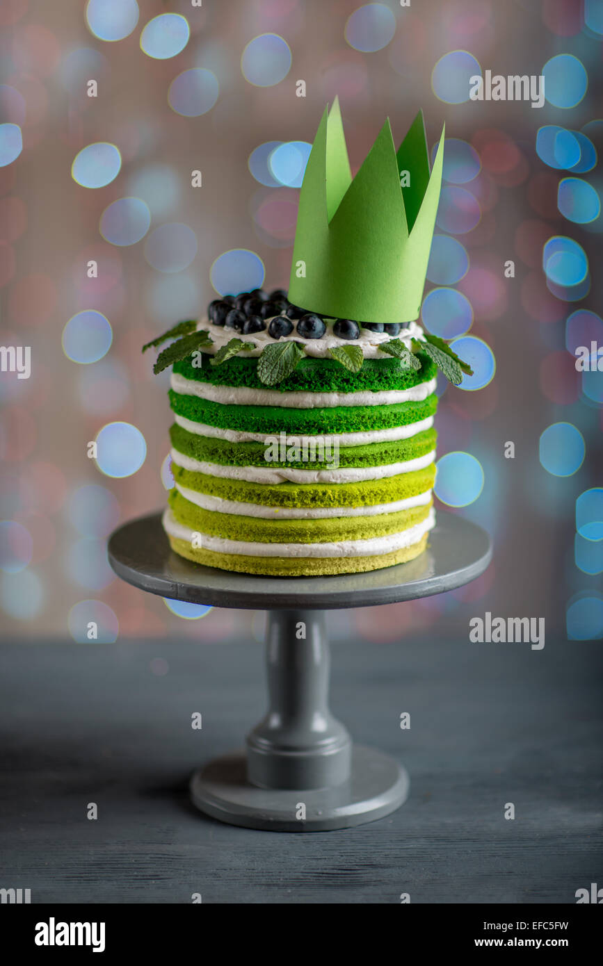 Bella spugna buon compleanno torta con mascarpone e uva sulla torta stand  con la corona sulla luce di festa sfondo bokeh di fondo Foto stock - Alamy