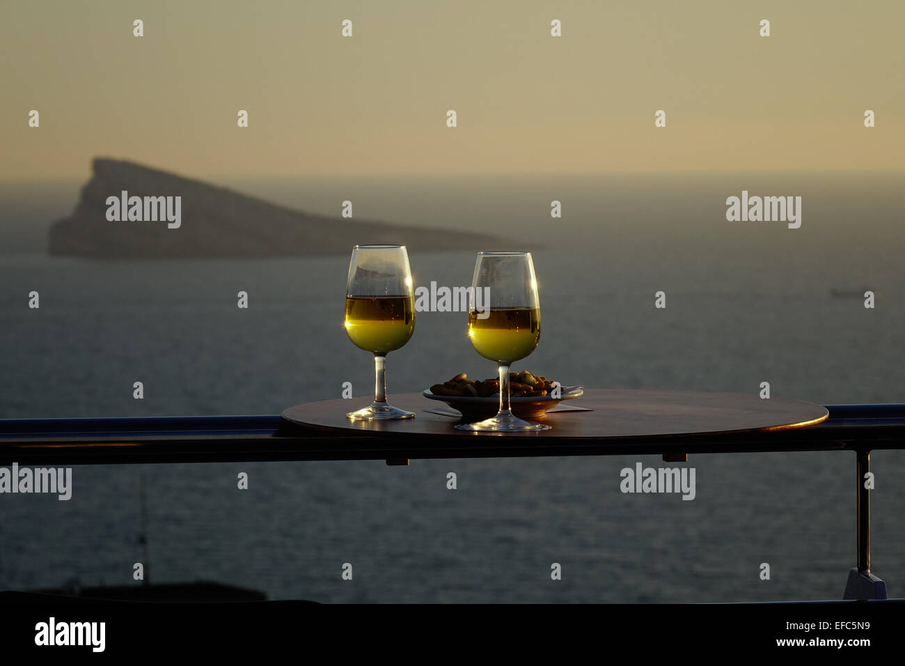 Bicchieri di vino bianco con snack presso il bar sul tetto e la vista del Peacock Island, Benidorm, Costa Blanca, Spagna Foto Stock