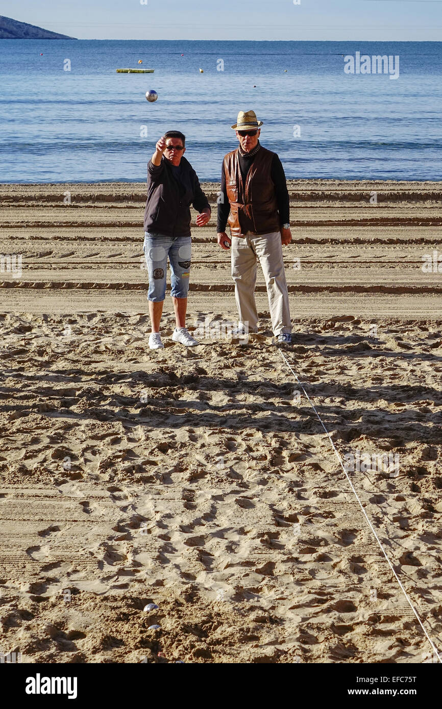 I pensionati e gli anziani a giocare palla di gioco sulla spiaggia, Peacock Island in background, Benidorm Costa Blanca, Spagna Foto Stock