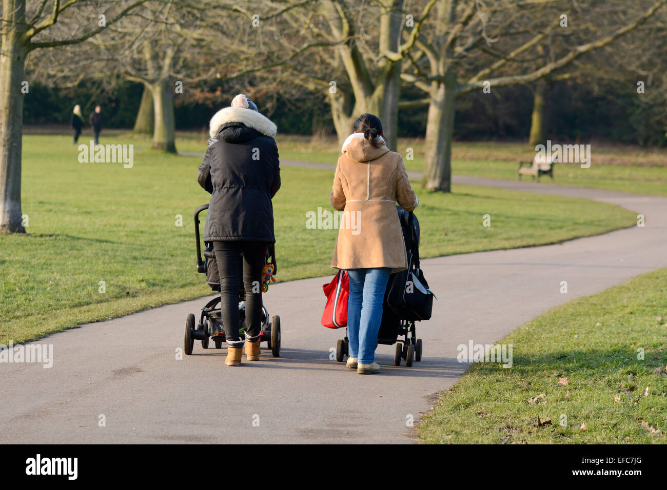 Due mamme spingendo i bambini il buggy in Bedford Park, Bedford, Bedfordshire, Inghilterra Foto Stock