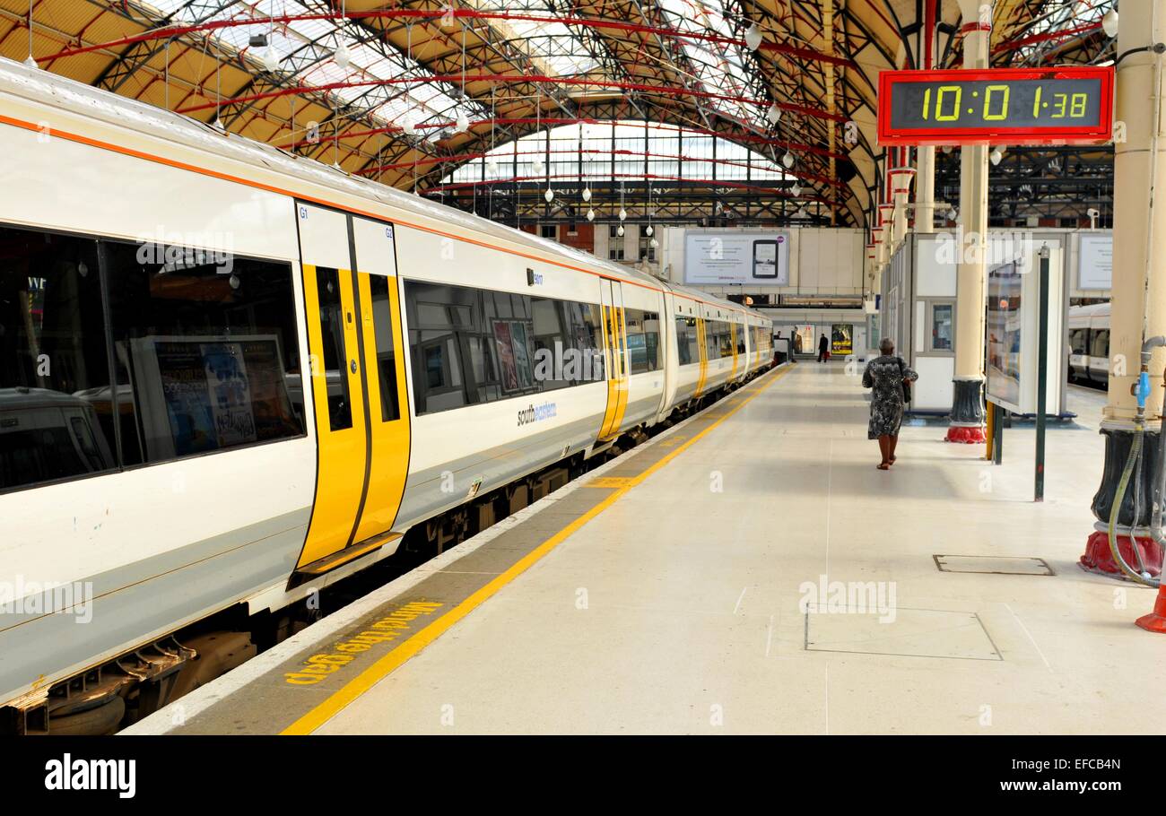 LONDON, Regno Unito - 9 Luglio 2014: A sud est treno lascia la piattaforma nella stazione ferroviaria di Victoria. Foto Stock