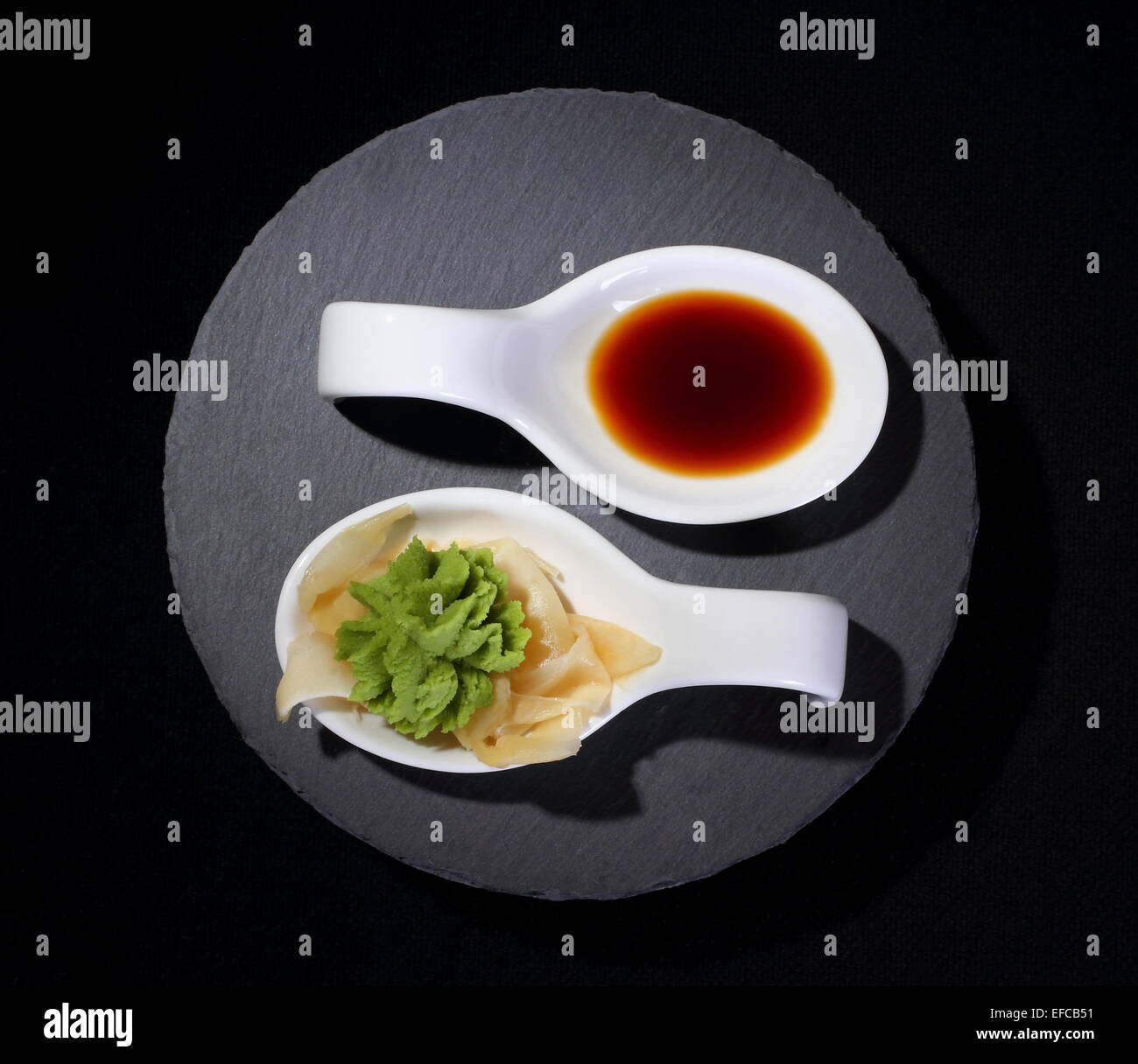 Wasabi e salsa di soia come yin e yang simbolo su nero Foto Stock