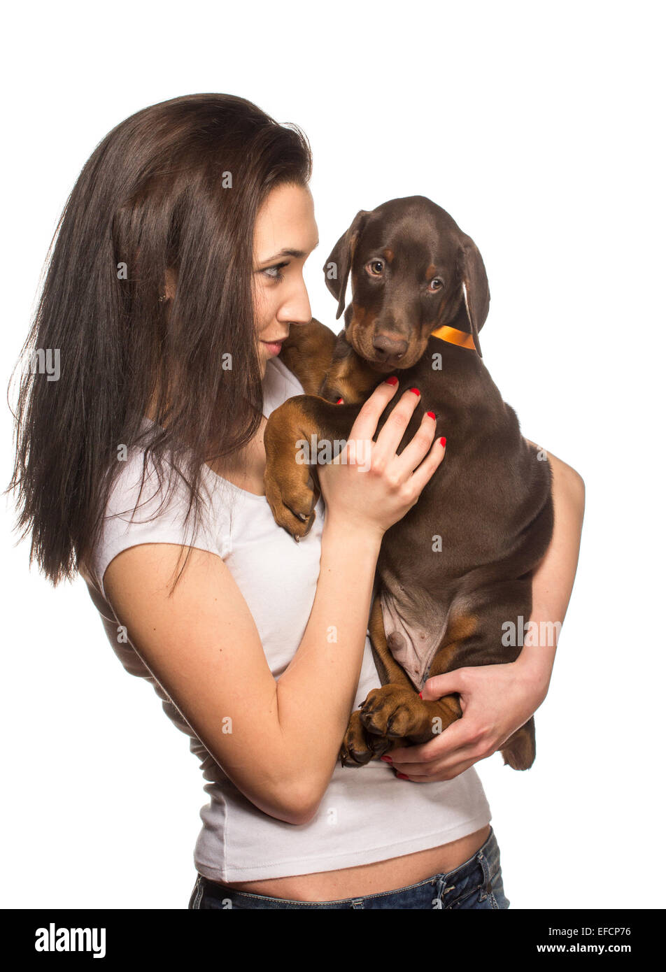 Bruna ragazza baciare il suo cucciolo doberman isolati su sfondo bianco Foto Stock
