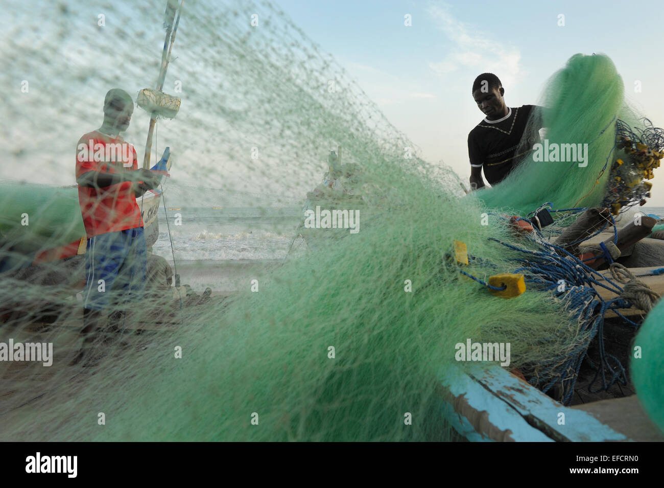 I pescatori sistemare le reti dopo una giornata di pesca al largo della costa vicino a Accra, Ghana, Africa occidentale. Foto Stock