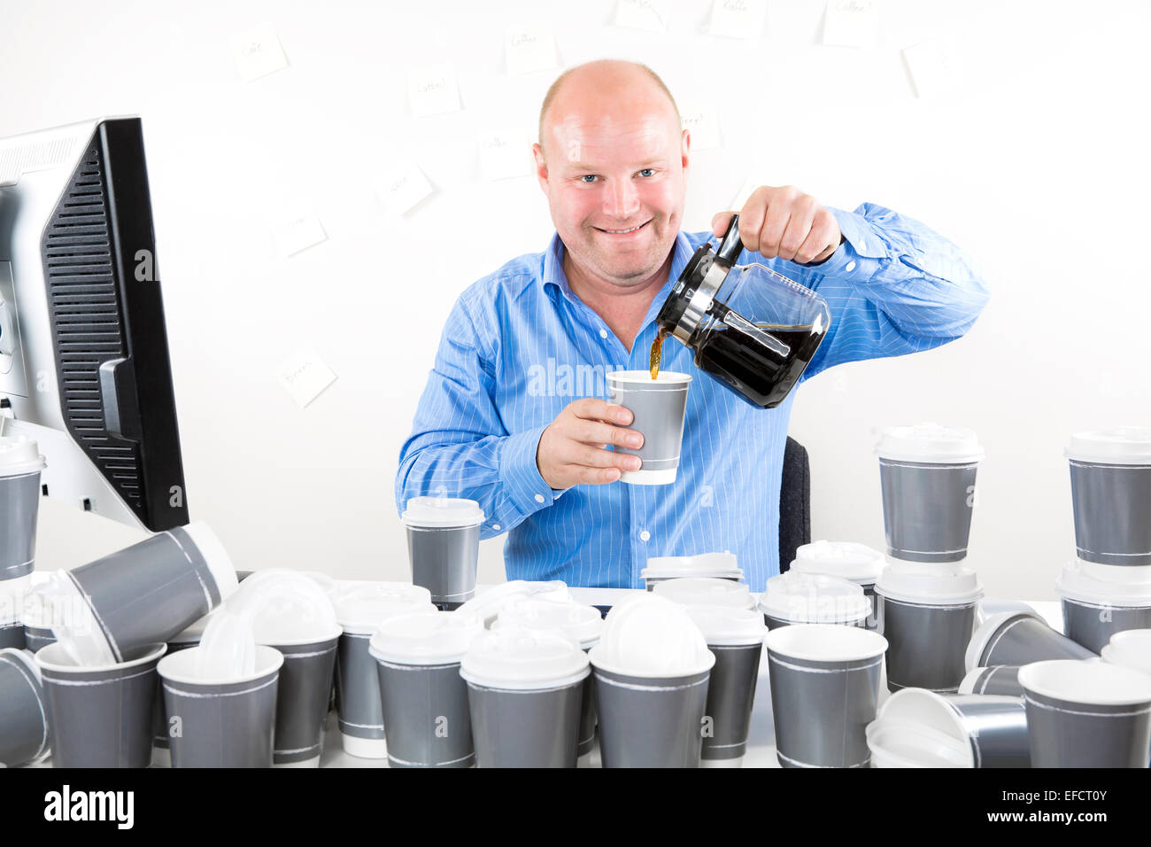 Felice lavoratore di ufficio beve troppo caffè Foto Stock