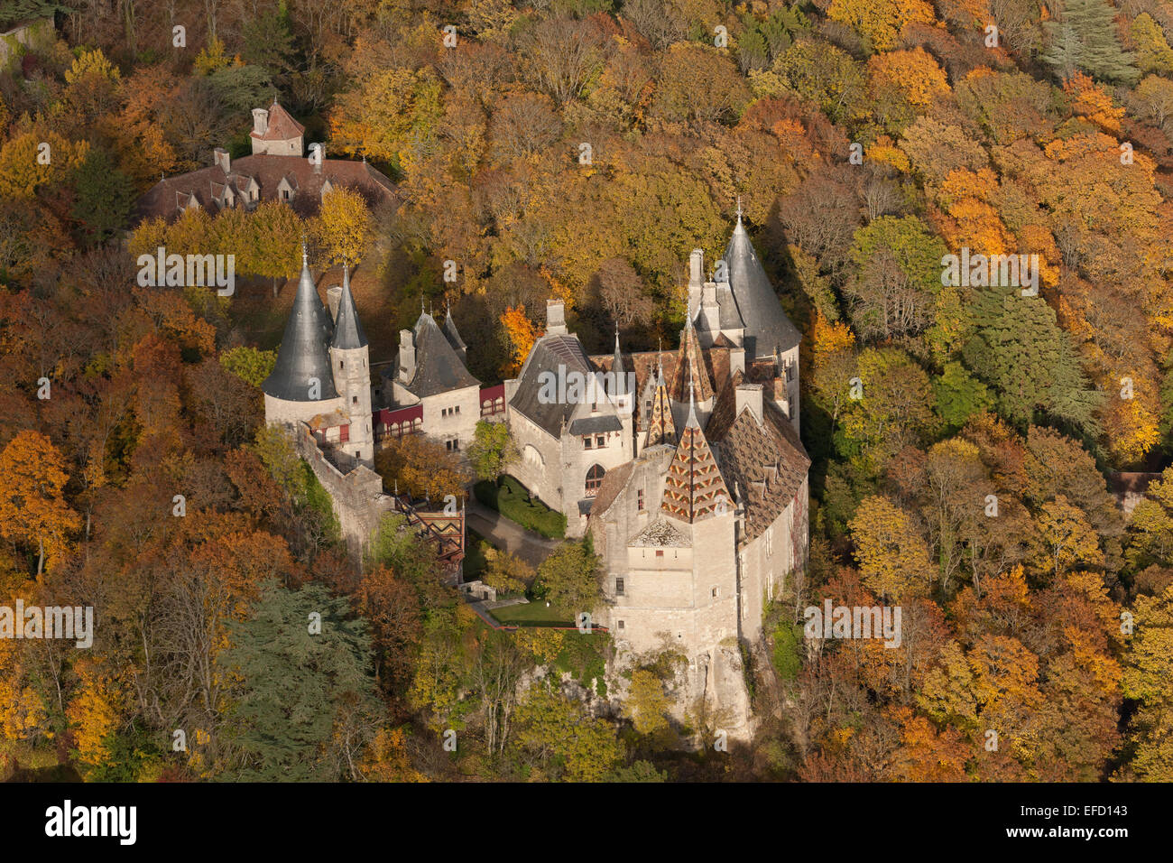 VISTA AEREA. Castello medievale in una zona boschiva dai colori autunnali. Castello di la Rochepot, Côte d'Or, Bourgogne-Franche-Comté, Francia. Foto Stock