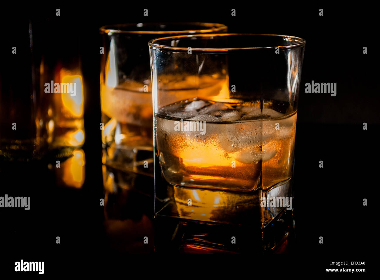 Whiskey bourbon o rum marrone nero su sfondo di riflessione Foto Stock
