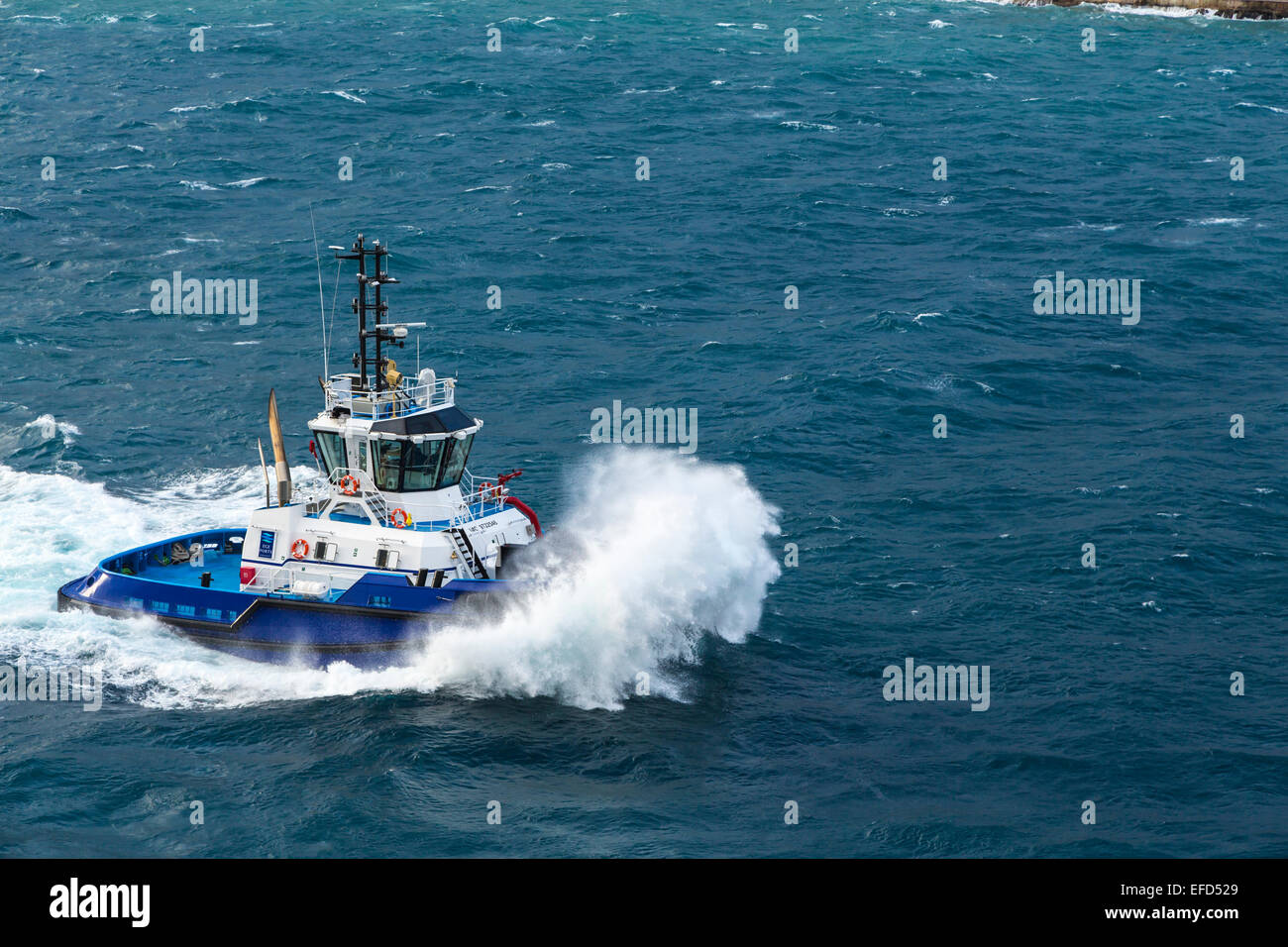 Un rimorchiatore a traino combattendo le onde nel porto di Kusadasi, Turchia, Eurasia. Foto Stock