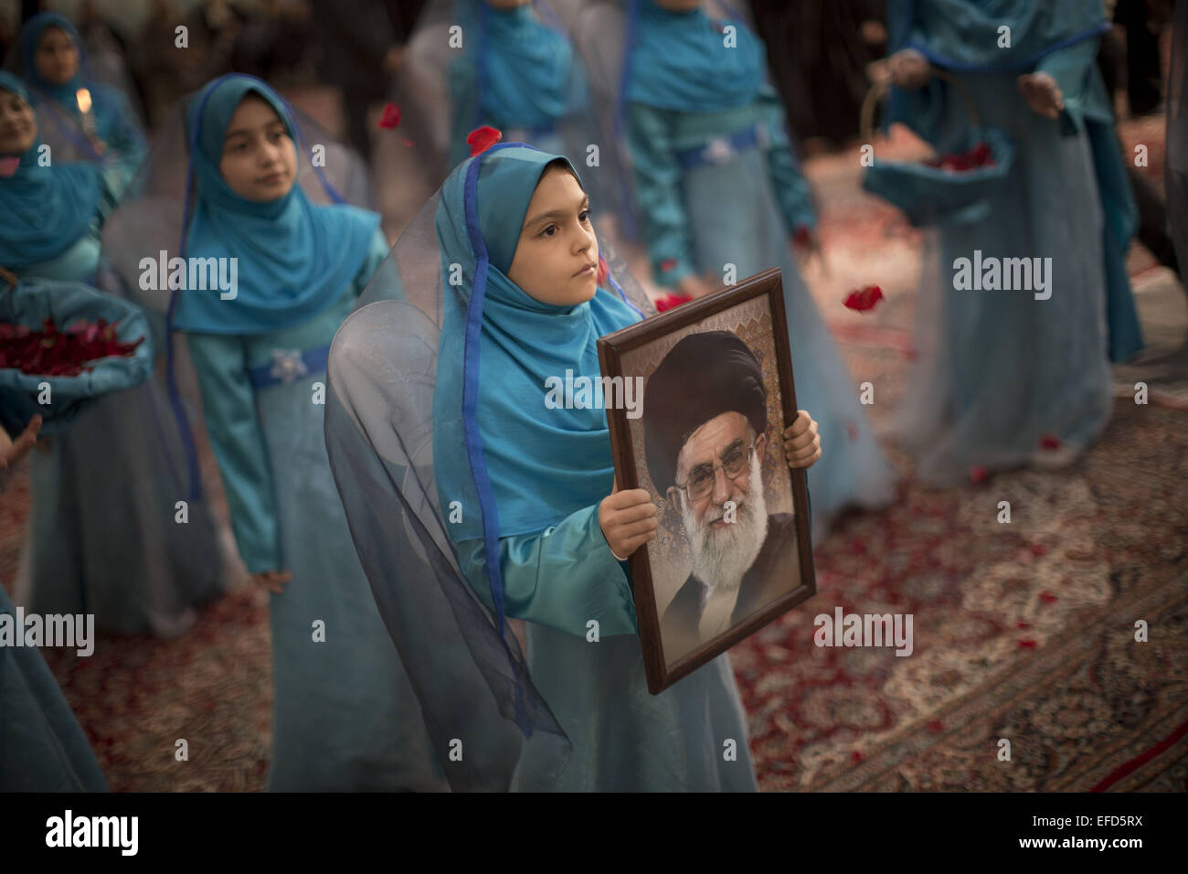Tehran, Iran. Il 1° febbraio 2015. Il governo iraniano schoolgirl contiene un ritratto di Iran del leader supremo Ayatollah Ali Khamenei presso la tomba di Iran del defunto capo Ayatollah Ruhollah Khomeini durante una cerimonia di anniversario della rivoluzione islamica nel Sud di Tehran. Morteza Nikoubazl/ZUMAPRESS Credito: Morteza Nikoubazl/ZUMA filo/Alamy Live News Foto Stock