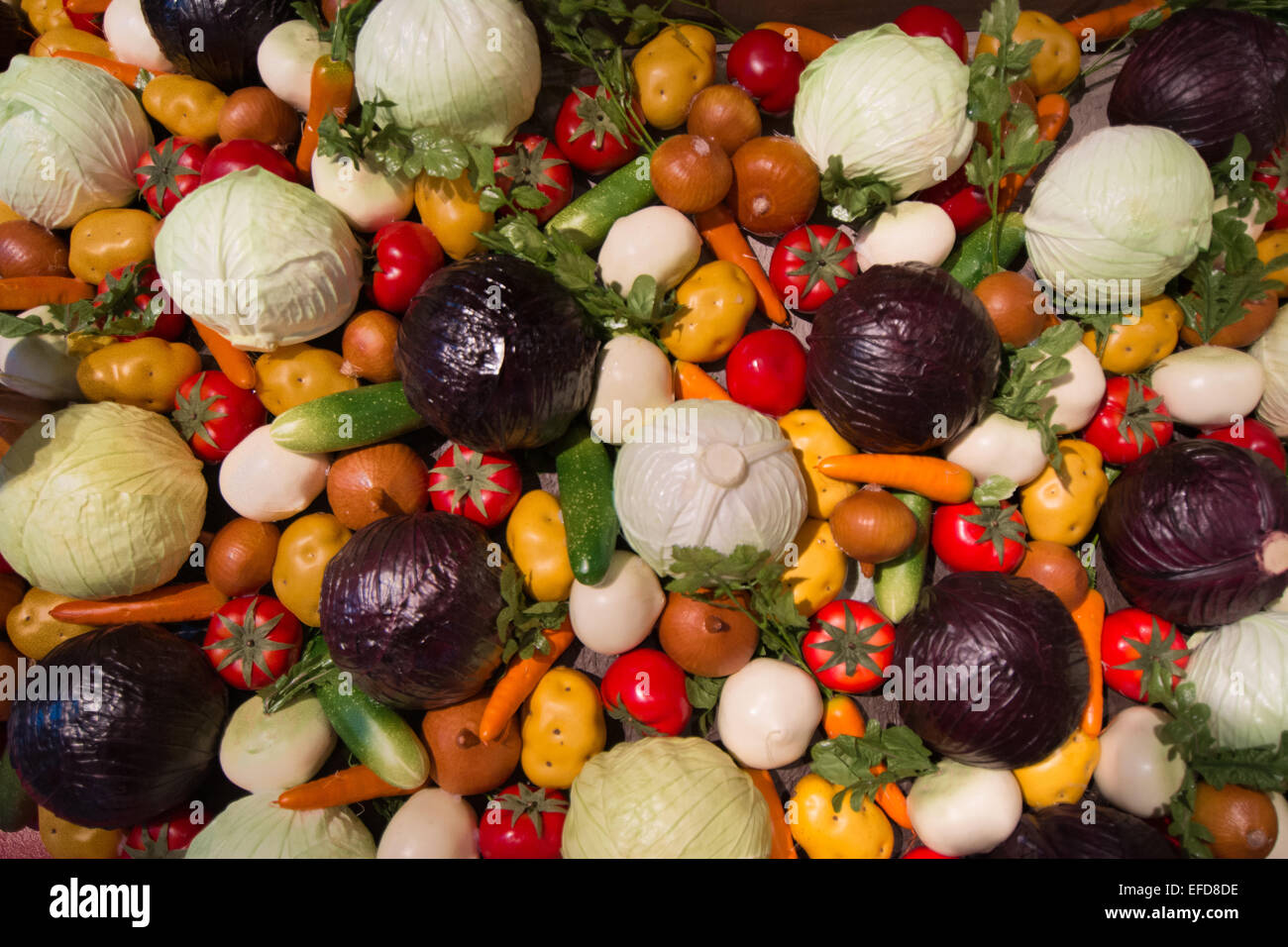 Una grande raccolta di faux verdure compresi i pomodori, cetrioli, zucchine, patate e cavolo, cavolo rosso cipolle e altro ancora. Foto Stock