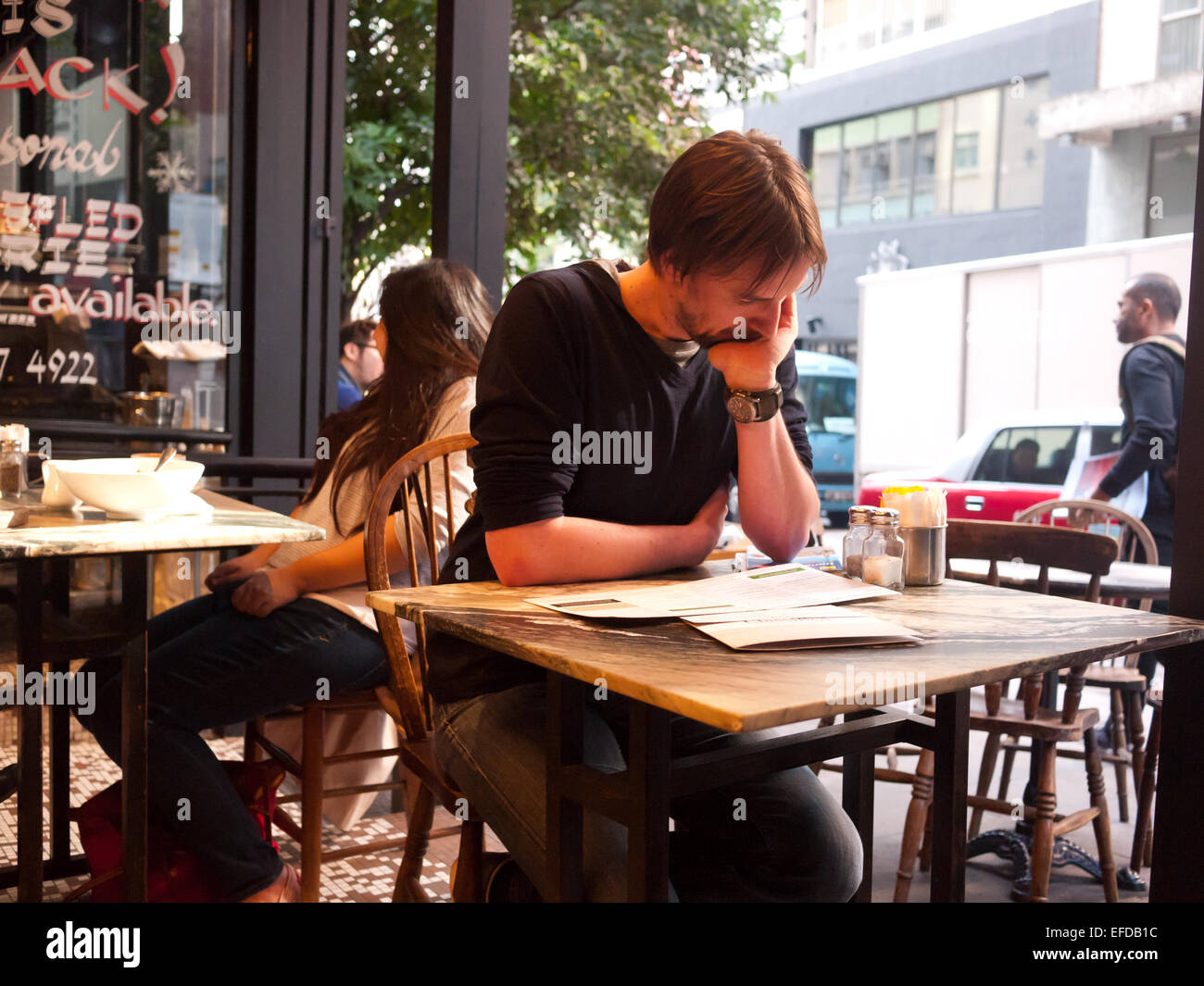 Hong Kong 2015 - Uomo leggendo il giornale in un cafe Foto Stock