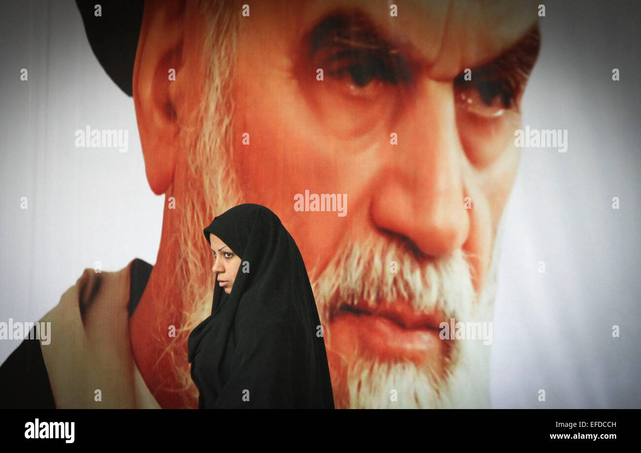 Tehran. Il 1° febbraio 2015. Una donna iraniana passeggiate passato un poster dell'Iran del ritardo di rivoluzione islamica leader Ayatollah Ruhollah Khomeini durante una cerimonia segna il 36o anniversario del ritorno dall esilio del fondatore dell'Iran la repubblica islamica, l Ayatollah Ruhollah Khomeini nel Febbraio 1, 2015 a Khomeini il mausoleo in un sobborgo di Teheran. Credito: Ahmad Halabisaz/Xinhua/Alamy Live News Foto Stock