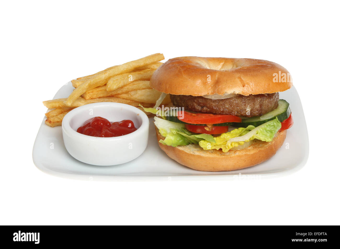 Hamburger di manzo in un bagel con patate fritte e il ketchup su una piastra isolata contro bianco Foto Stock