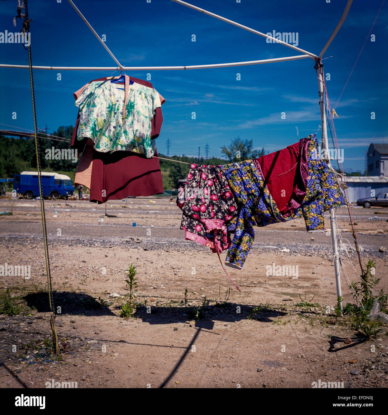 Appendere abiti colorati su uno stand di mercato in metallo, mercato vuoto Foto Stock