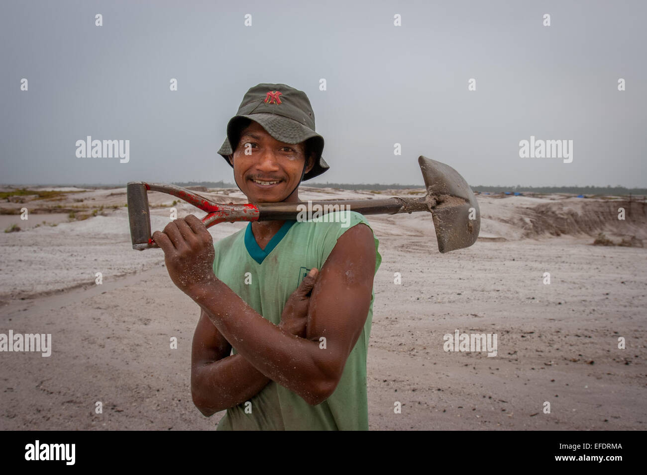 Ritratto di un minatore d'oro in scala ridotta che porta una pala ad Hampalit, Kalimantan centrale, Indonesia. Foto Stock