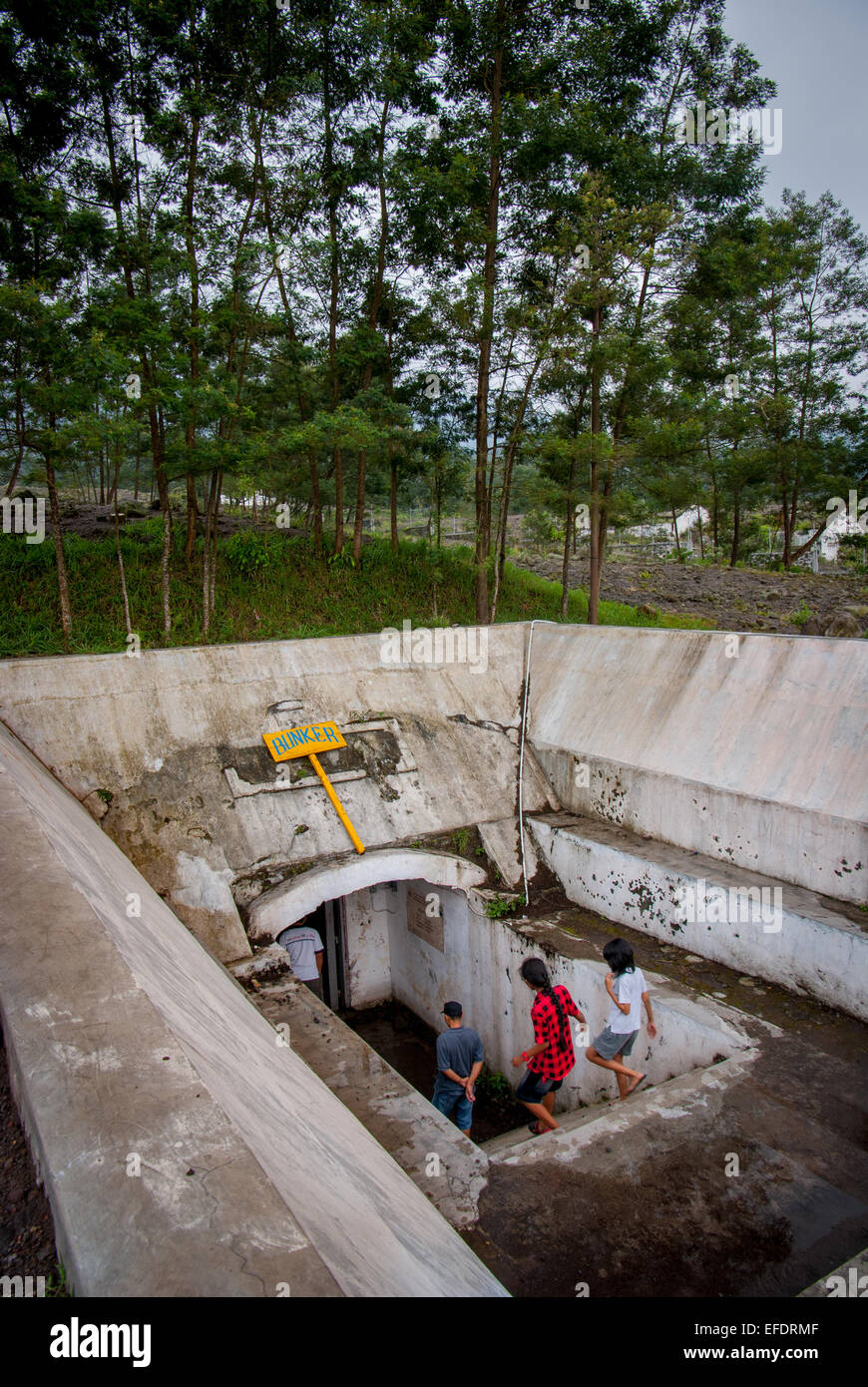 Curiosi visitatori locali entrando in emergenza bunker sotterraneo sul pendio del Monte Merapi, Yogyakarta, Indonesia. Foto Stock