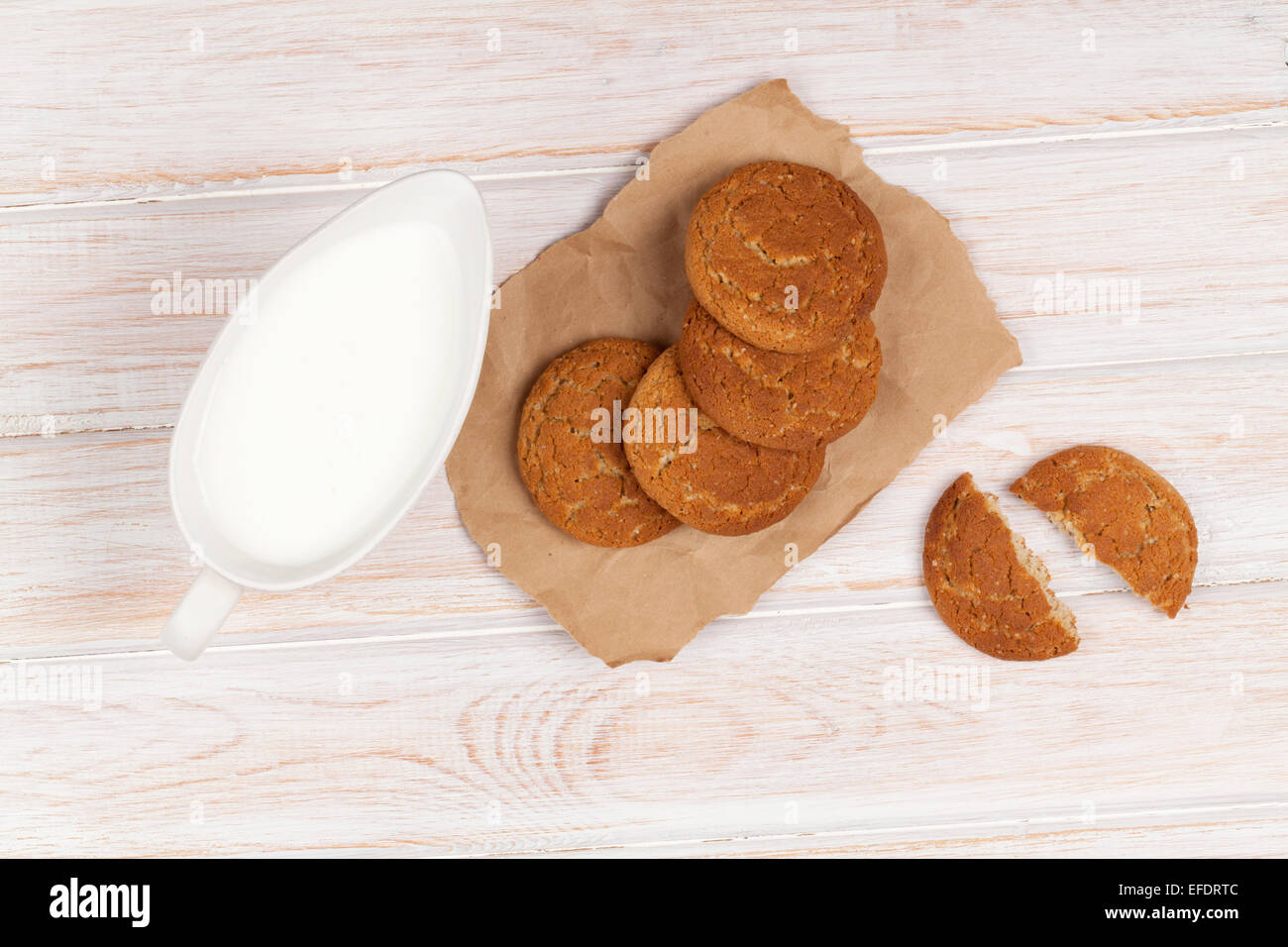 Brocca del latte e biscotti di panpepato su bianco tavolo in legno Foto Stock