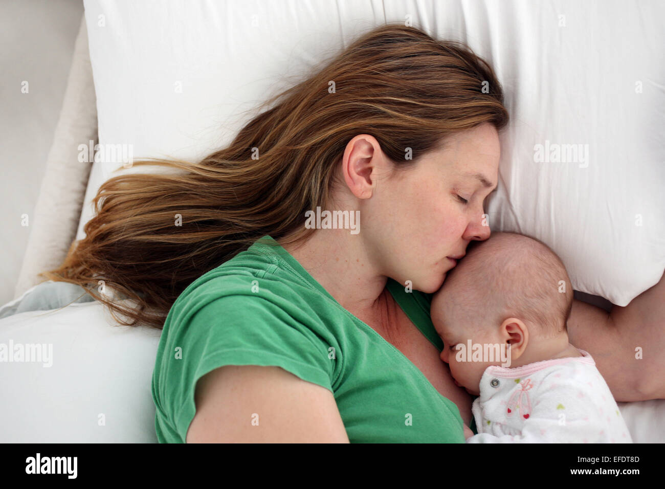 Un neonato è coccolato da sua madre mentre dormiva. Foto Tim Clayton Foto Stock