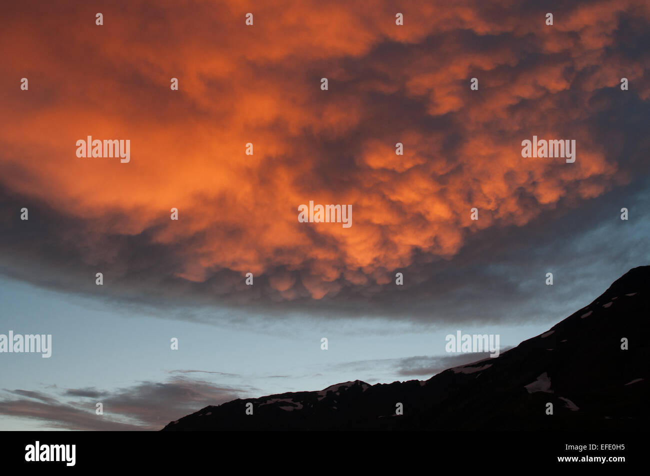 Rosso Brillante nube ha dangled oltre le montagne. Si tratta di un tramonto in montagna. Foto Stock