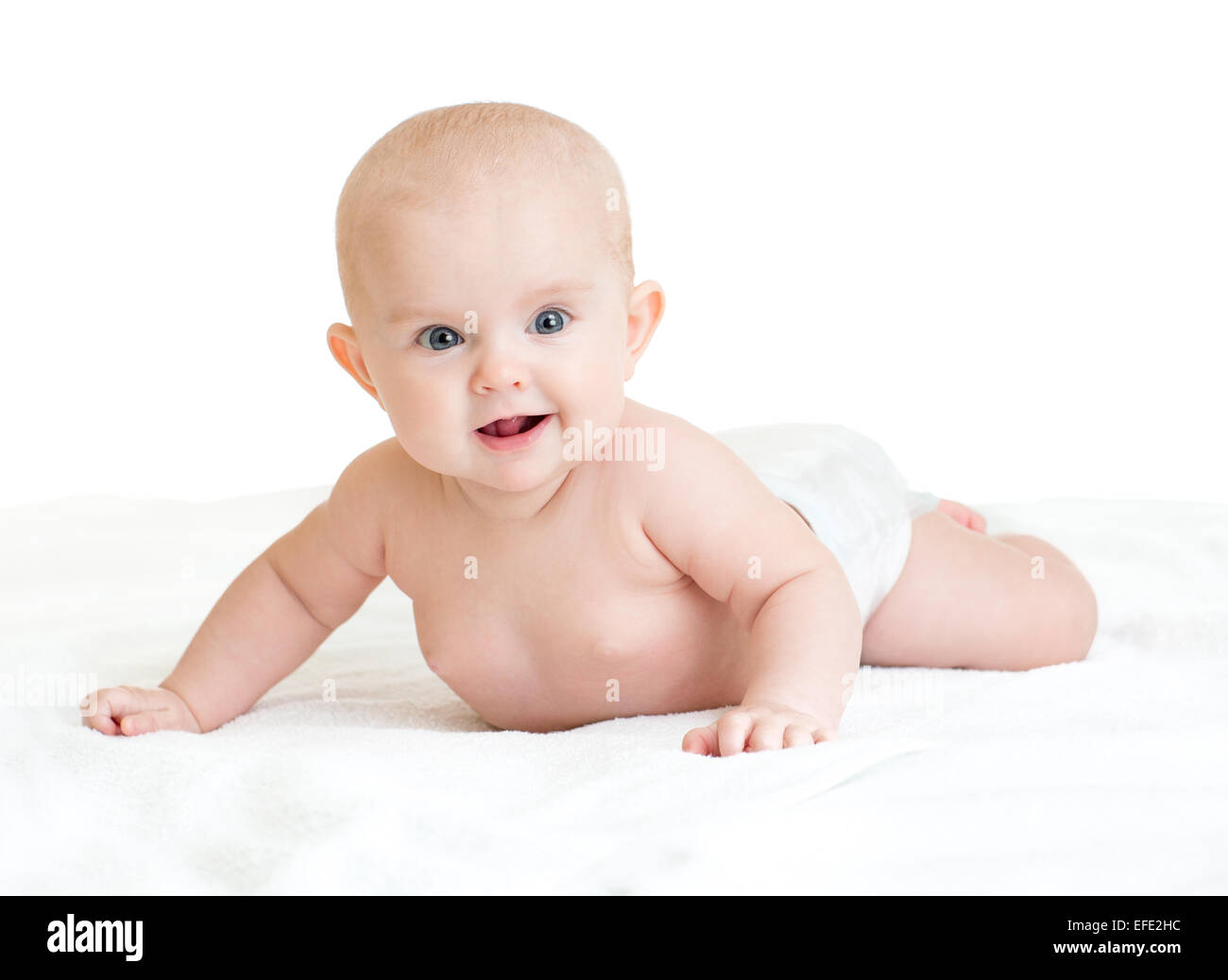 Carino sorridente bambino giacente su asciugamano bianco nel pannolino Foto Stock