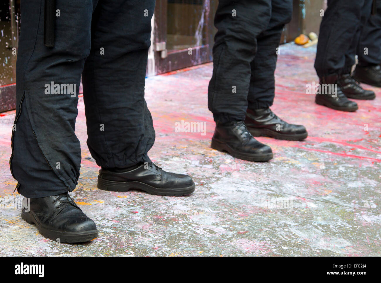 Funzionario di polizia's stivali e pantaloni. I funzionari sono a guardia Top Shop, Oxford Street nel corso del 2011 l'evasione fiscale protesta. Foto Stock