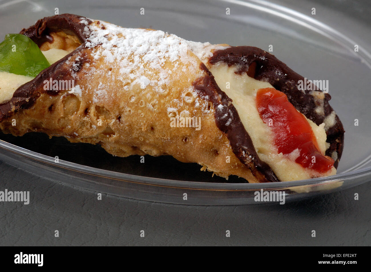 Dolce italiano (cannoli di pasta fritta con dolce ripieno cremoso) , con il rosso e il verde ciliegie al maraschino. Foto Stock