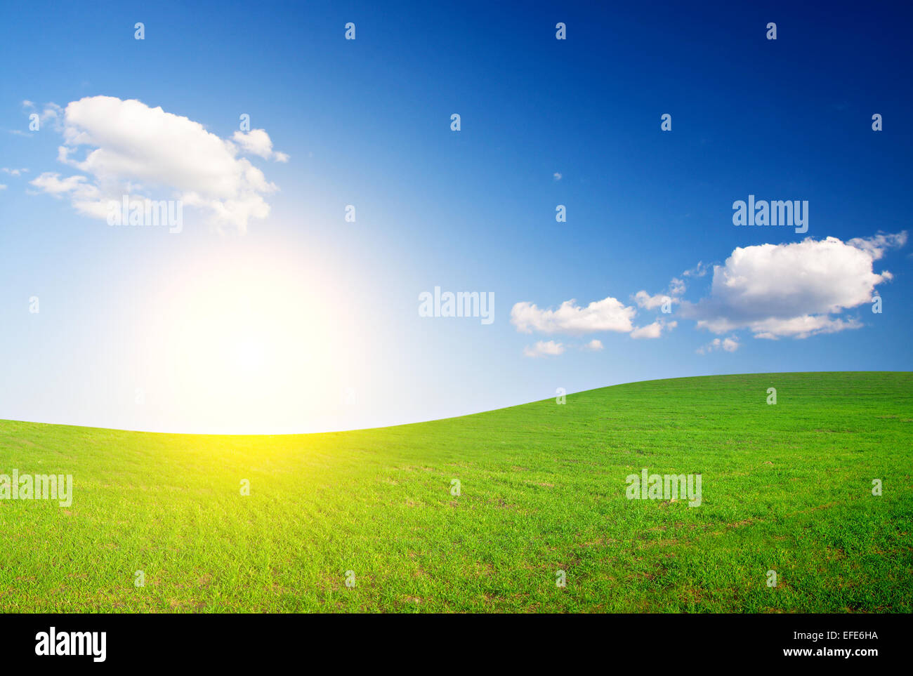 Verde collina sotto il blu cielo nuvoloso con Sun Foto Stock