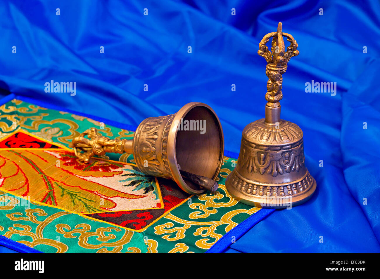 Due rituali tibetani campane su uno sfondo blu Foto Stock