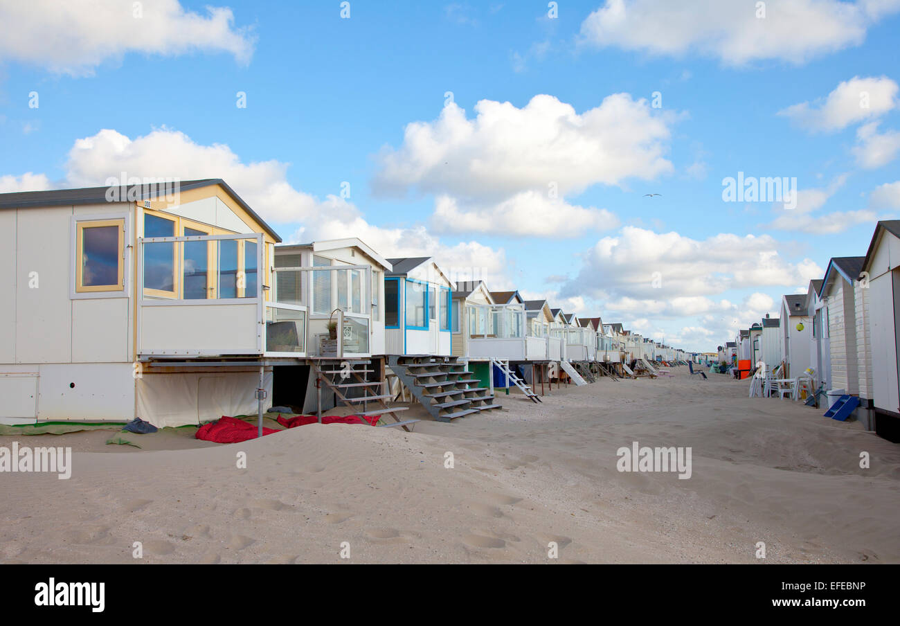 Case sulla spiaggia sulla spiaggia in una fila con cielo blu Foto Stock