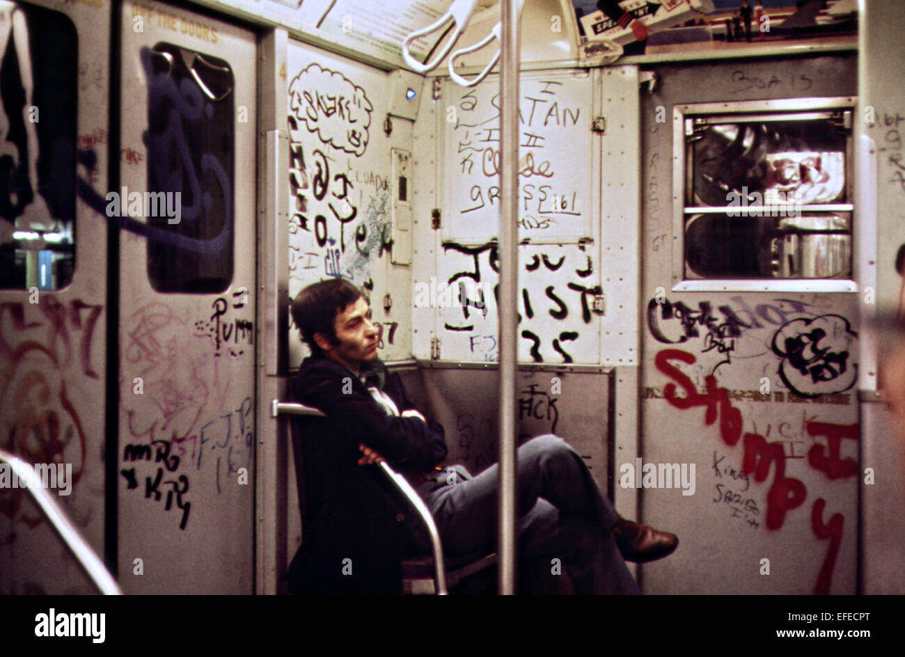 Un " commuter " si siede in un coperto di graffiti auto metropolitana maggio 1973 nella città di New York. Foto Stock