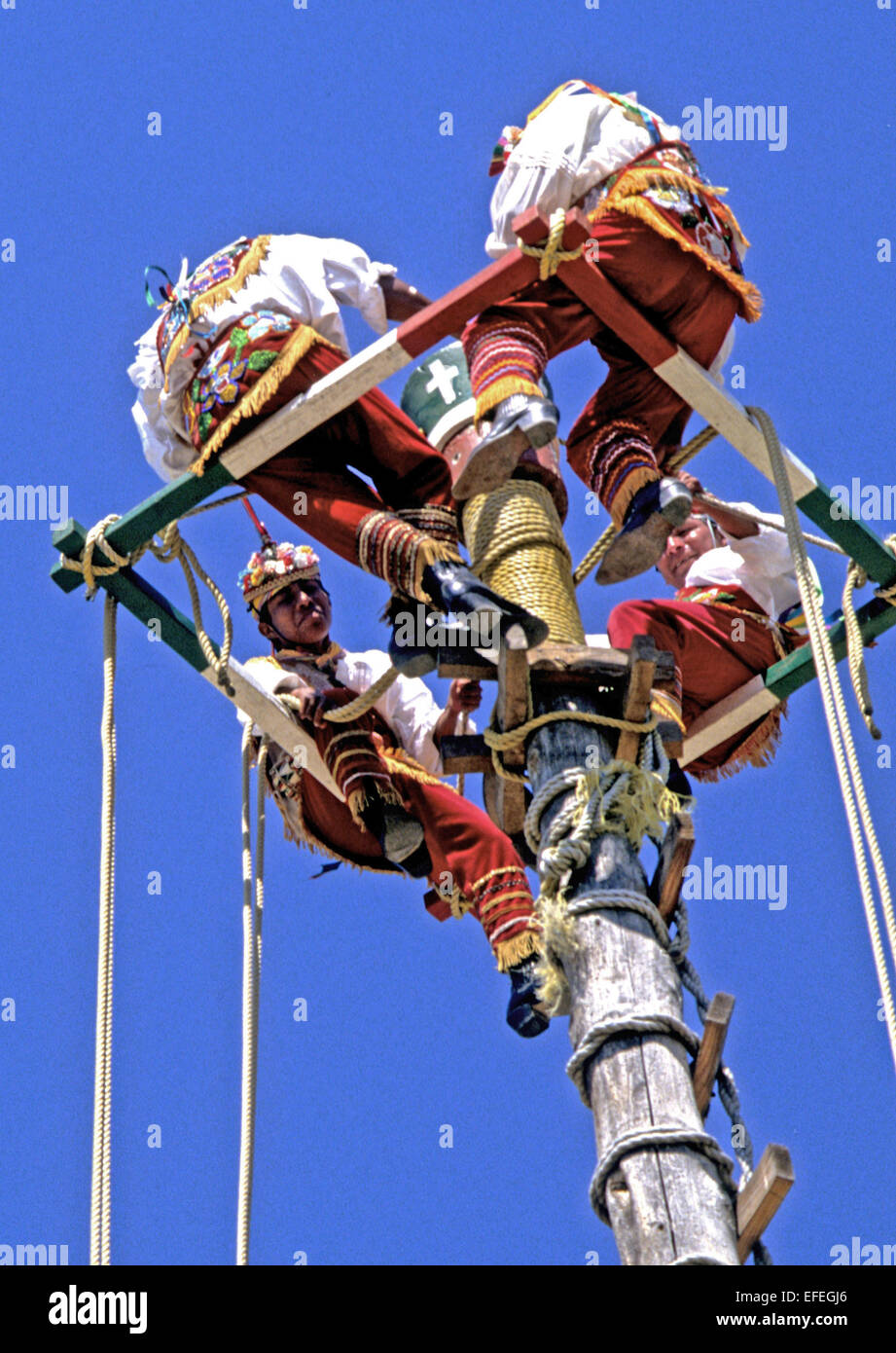 Messico - Totonac indiani eseguire la tessitura intricata dance routine sulla cima di un palo quasi 100 piedi in aria. Foto Stock