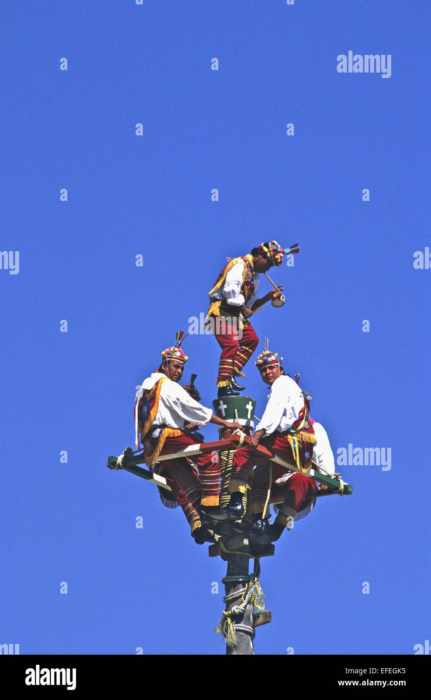 Messico - Totonac indiani eseguire la tessitura intricata dance routine sulla cima di un palo quasi 100 piedi in aria. Foto Stock