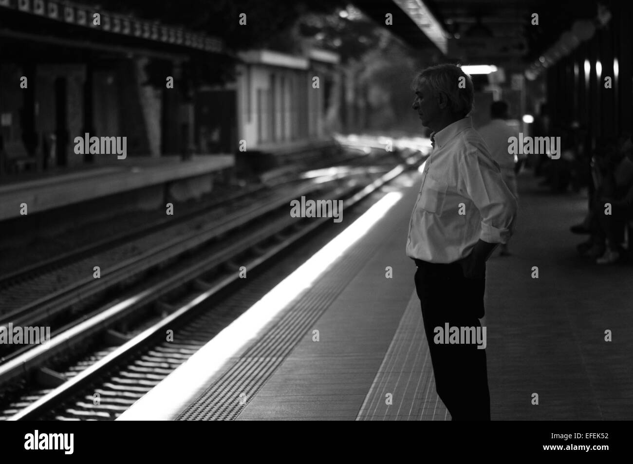 Il vecchio uomo di attesa per il treno nella stazione di Atene, Grecia Foto Stock